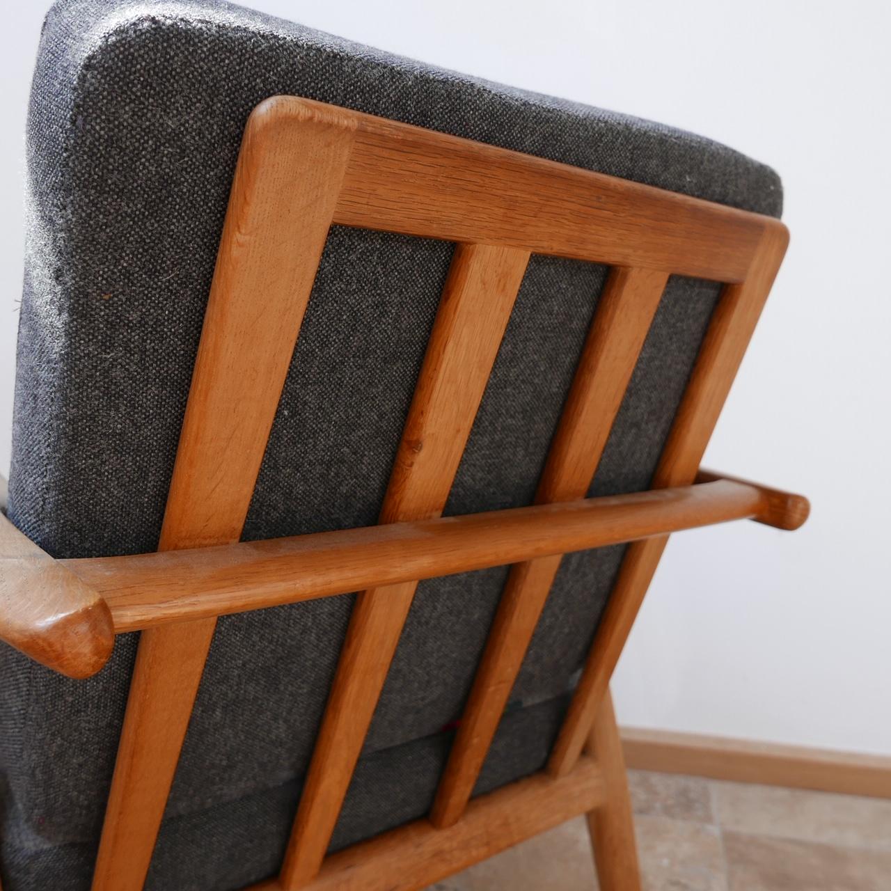 A smart armchairs by design legend Hans J. Wegner. 

Denmark, circa 1955-1965. 

Solid oak, original upholstery which is perfectly usable but has some signs of age, can be updated in house at cost. 

Good condition and timeless comfortable