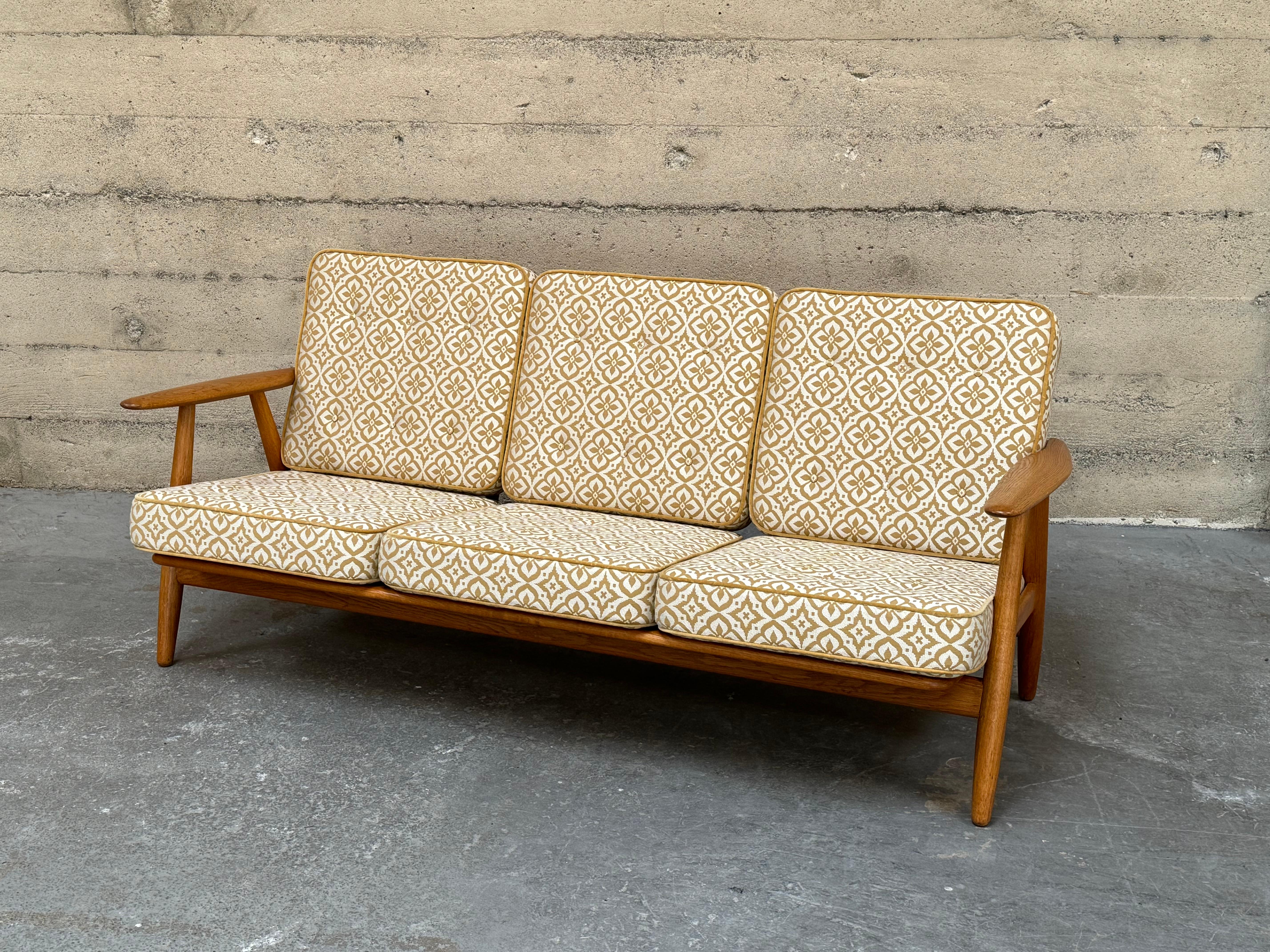 Classic Cigar sofa designed by Hans J. Wegner in oak. Reupholstered in a Kvadrat textile with velvet welt. Three seats. Beautiful frame in solid oak with original finish, made in Denmark circa 1960s. This oak framed design by Hans J Wegner has