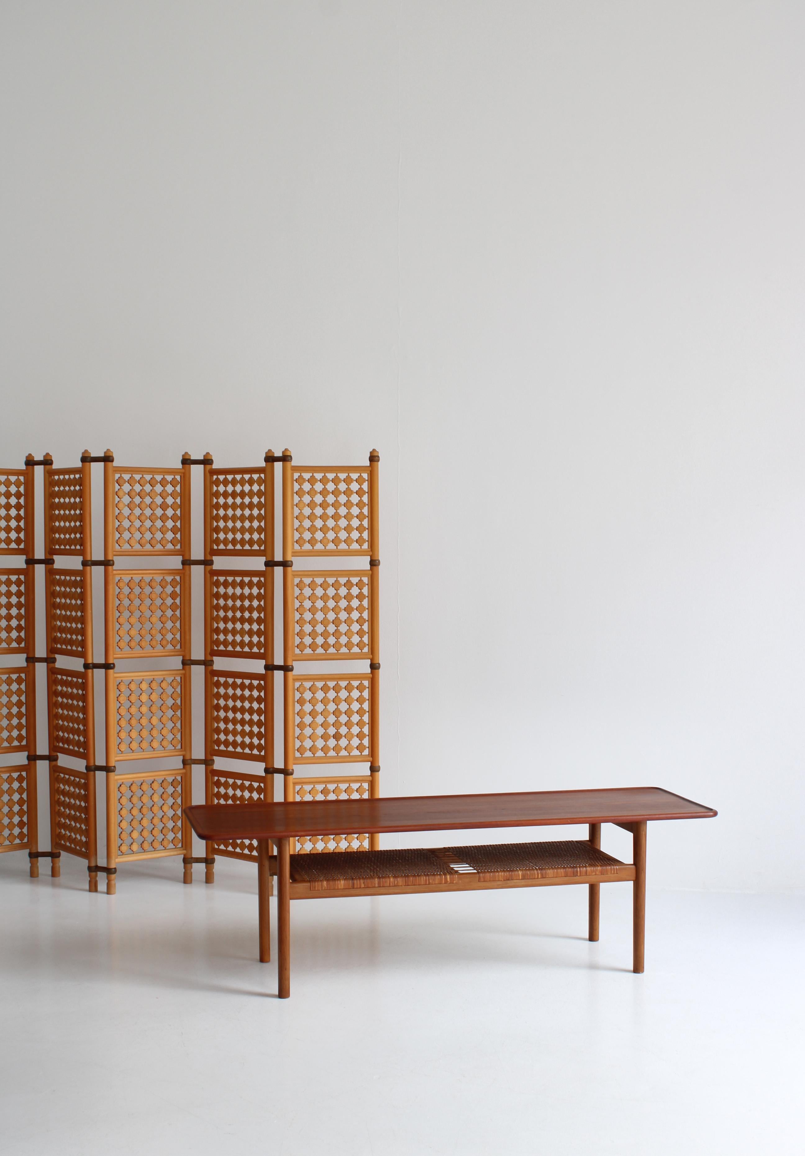 Iconic and rare Hans J. Wegner coffee table in solid teakwood, oak and rattan cane made by cabinetmaker Andreas Tuck, Odense, Denmark. This model 