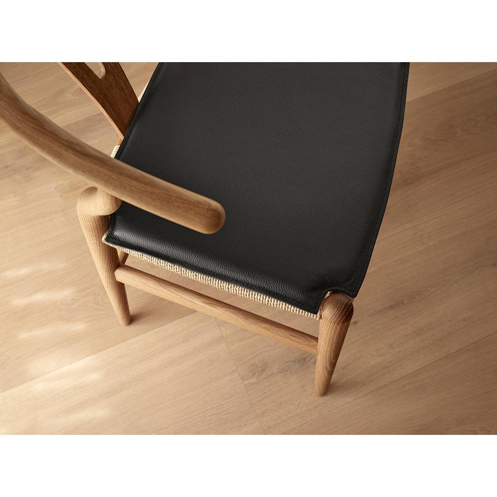 Das allererste Modell, das Hans J. Wegner 1949 exklusiv für Carl Hansen & Søn entwarf, der CH24 Wishbone Chair, wird seit seiner Einführung im Jahr 1950 kontinuierlich produziert. Bei der Gestaltung des CH24 entschied sich Wegner dafür, Rücken- und