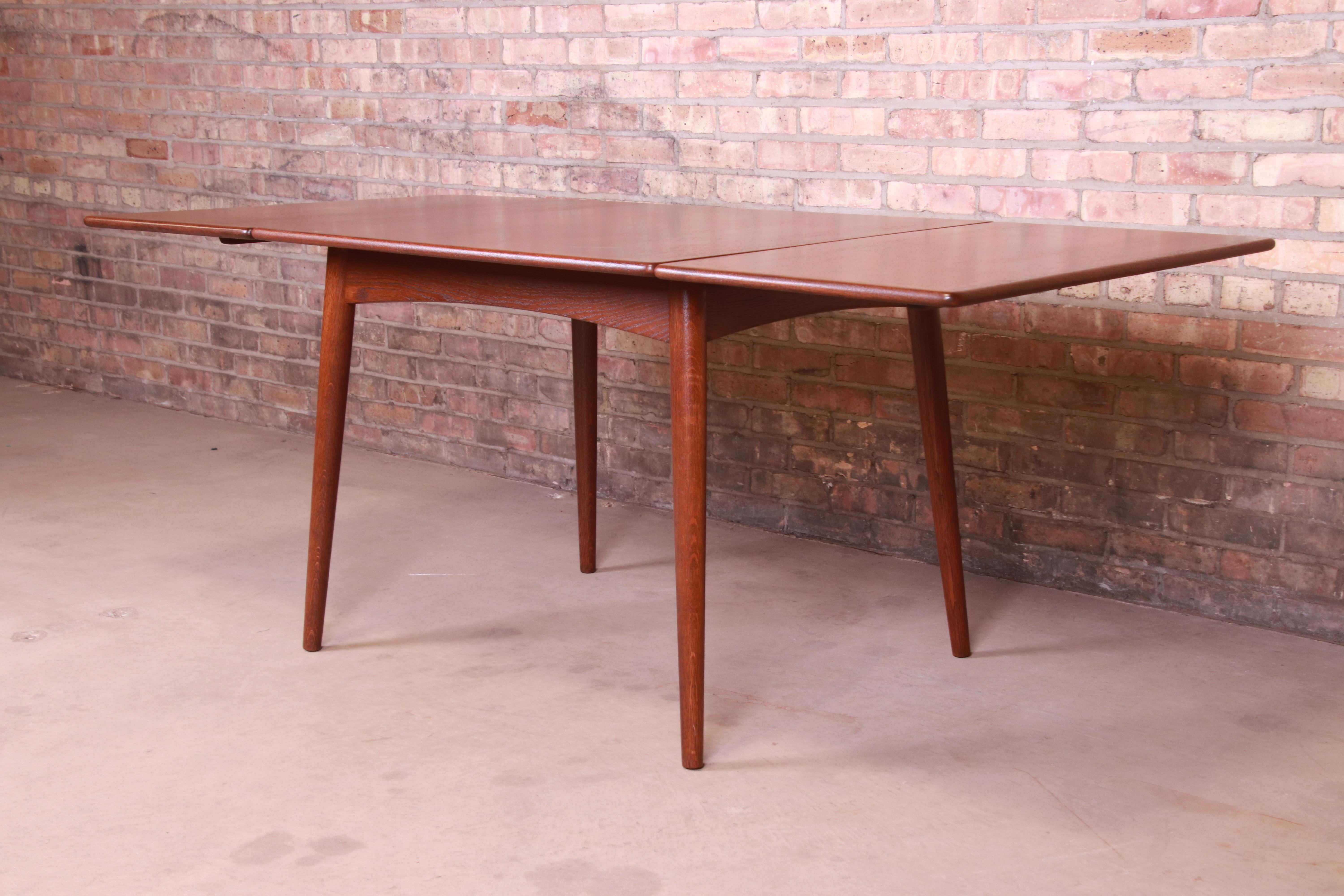 Rare et exceptionnelle table de salle à manger moderne danoise à pieds tombants

Par Hans J. Wegner pour Andreas Tuck

Danemark, années 1950

Plateau en bois de teck, sur des pieds fuselés en bois de chêne avec des tabliers