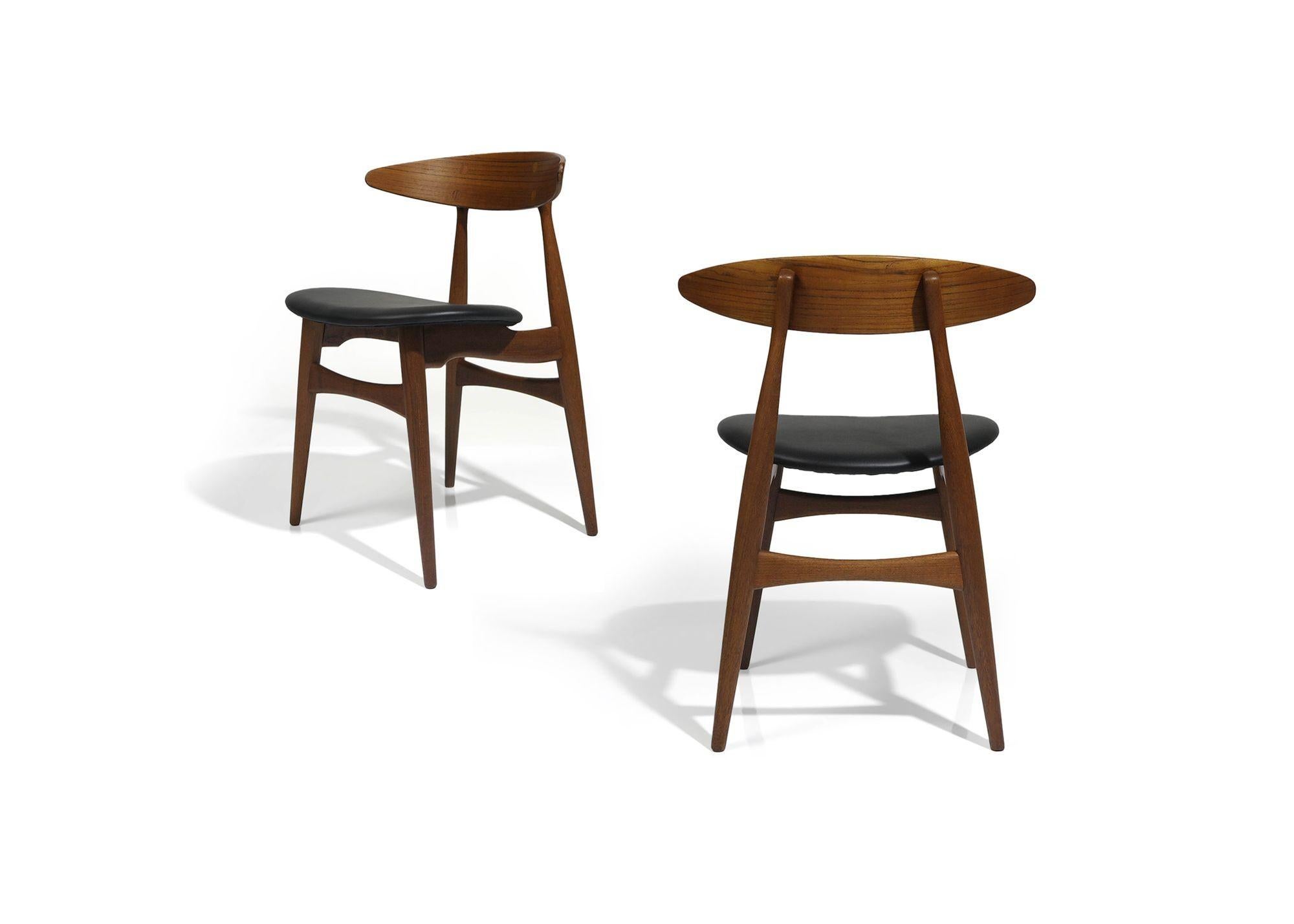 Chaises de salle à manger CH33 sculptées par Hans Wegner, conçues en 1957, pour Carl Hansen & Son, fabriquées entre 1957 et 1967. Ces chaises sont dotées d'un dossier incurvé spectaculaire et de nouveaux sièges en cuir. Elles sont considérées comme