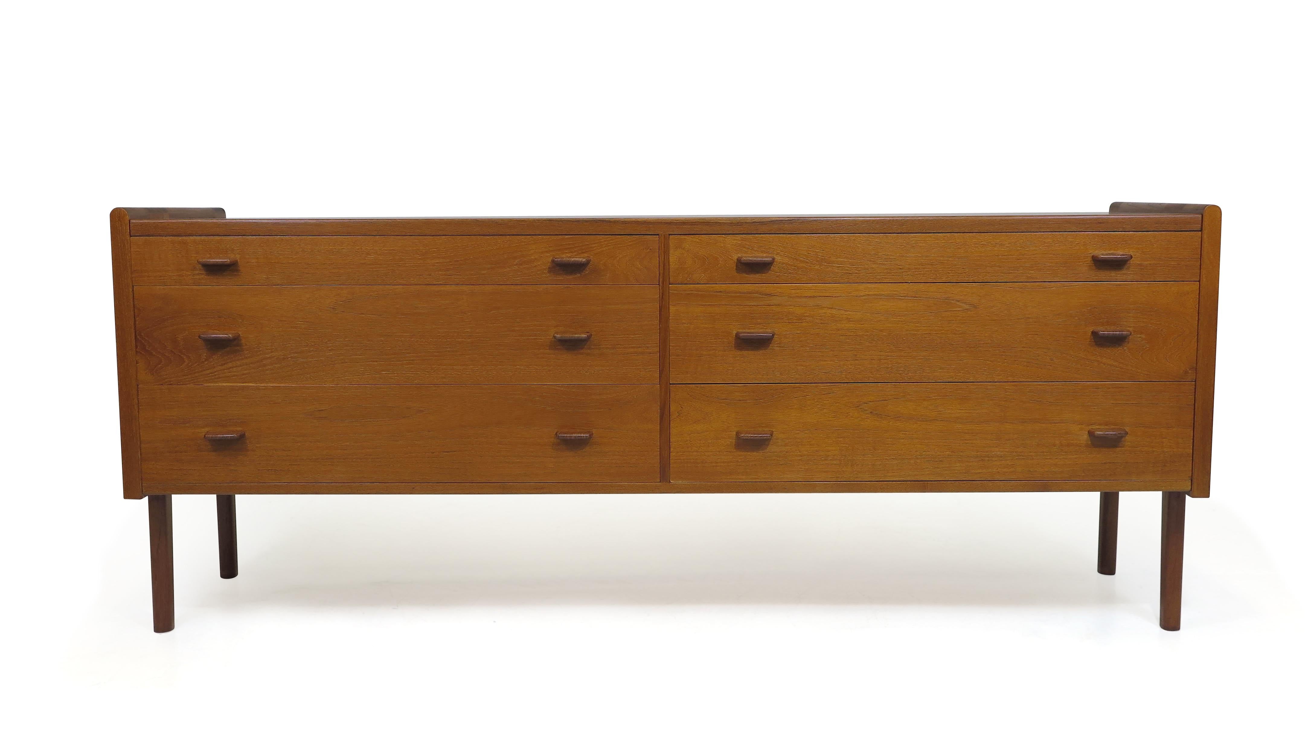 Teak dresser designed by Hans Wegner for Ry Mobler 1958 Denmark. The dresser is finely crafted of teak with six drawers, sculpted hand pulls, and raised on solid teak legs. Excellent condition with minor signs of age and use.