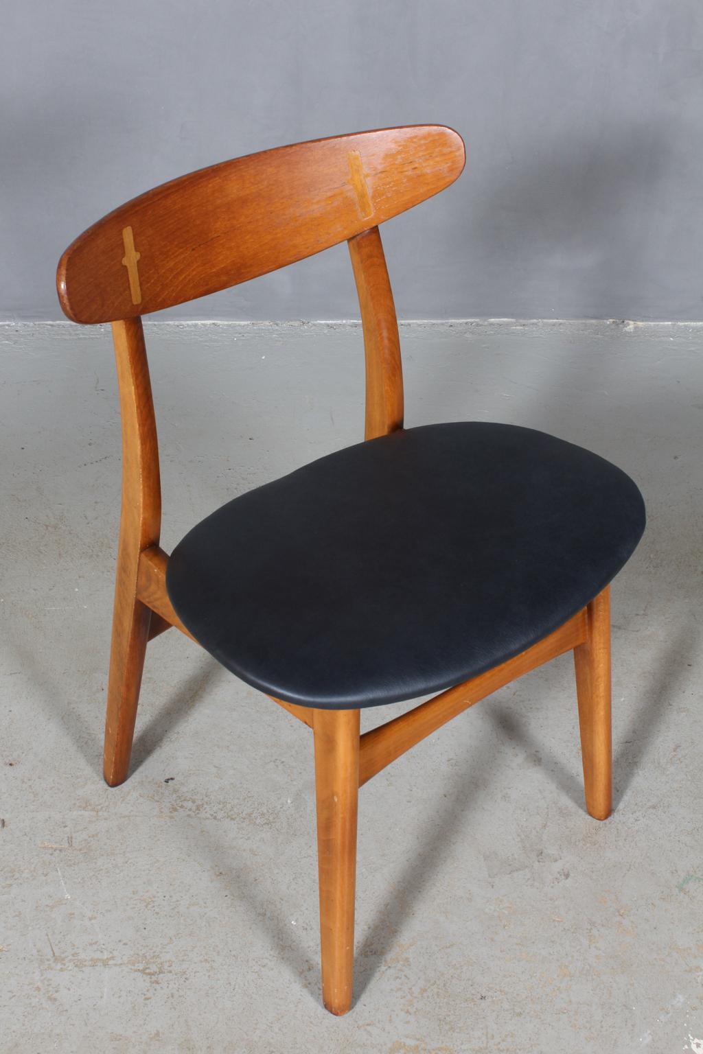Hans J. Wegner dining chair in beech and teak.

New upholstered with black aniline leather.

The CH-30 was originally designed in 1952 and was one of Wegner’s first chairs. The design has become a Classic with the exposed joint between the