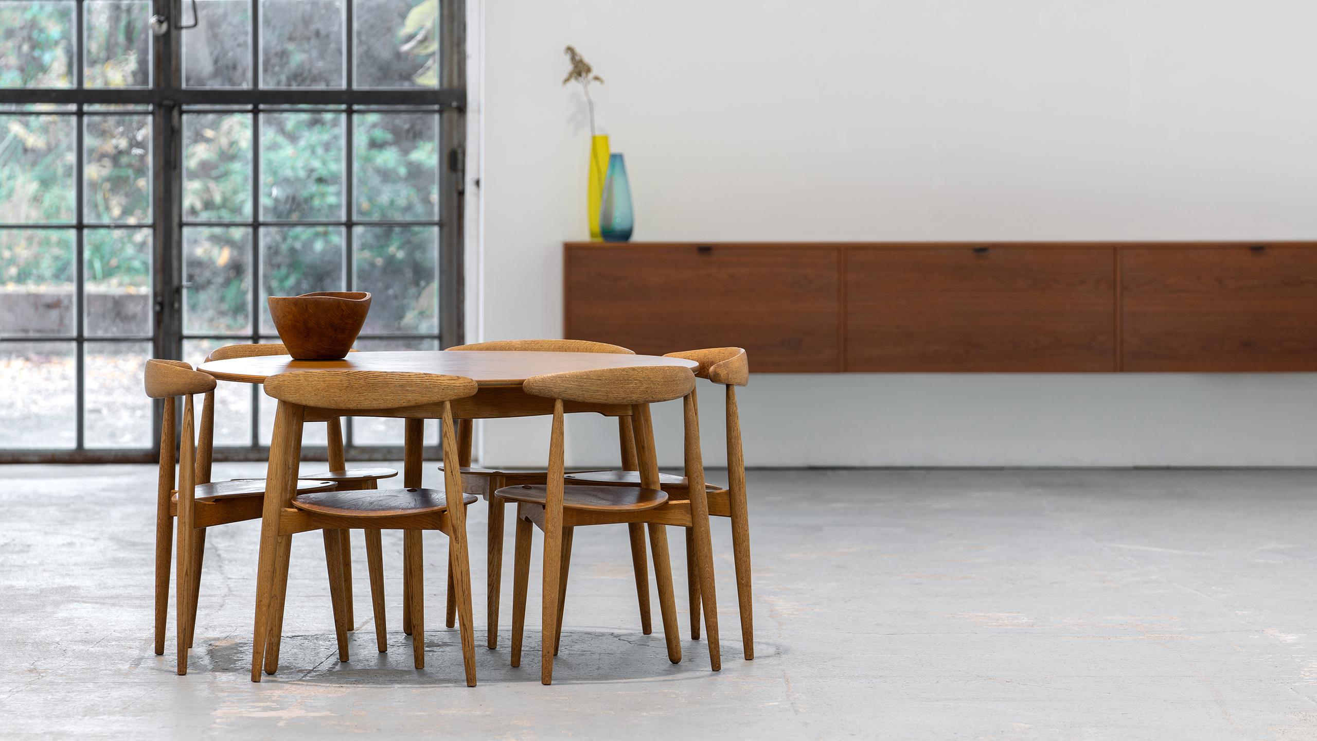 Insanely beautiful and inviting dining group by Hans J. Wegner for Fritz Hansen, Denmark in 1958. 
Consisting of a 3-legged table with 6 stackable 