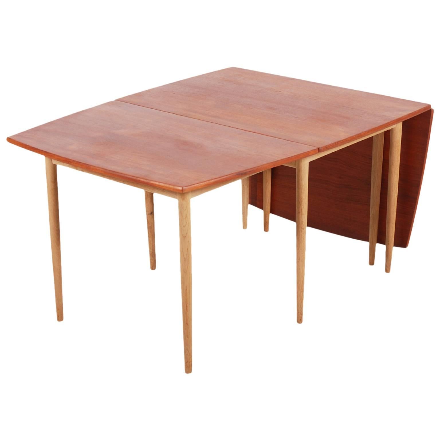 Very nice drop-leaf dining table designed by the Danish designer Hans Wegner and manufactured by Andreas Tuck. Made in Denmark, 1960.

The table is made of a combination of two wood species, Oak for the feet and veneered Teak for the top.
Up to