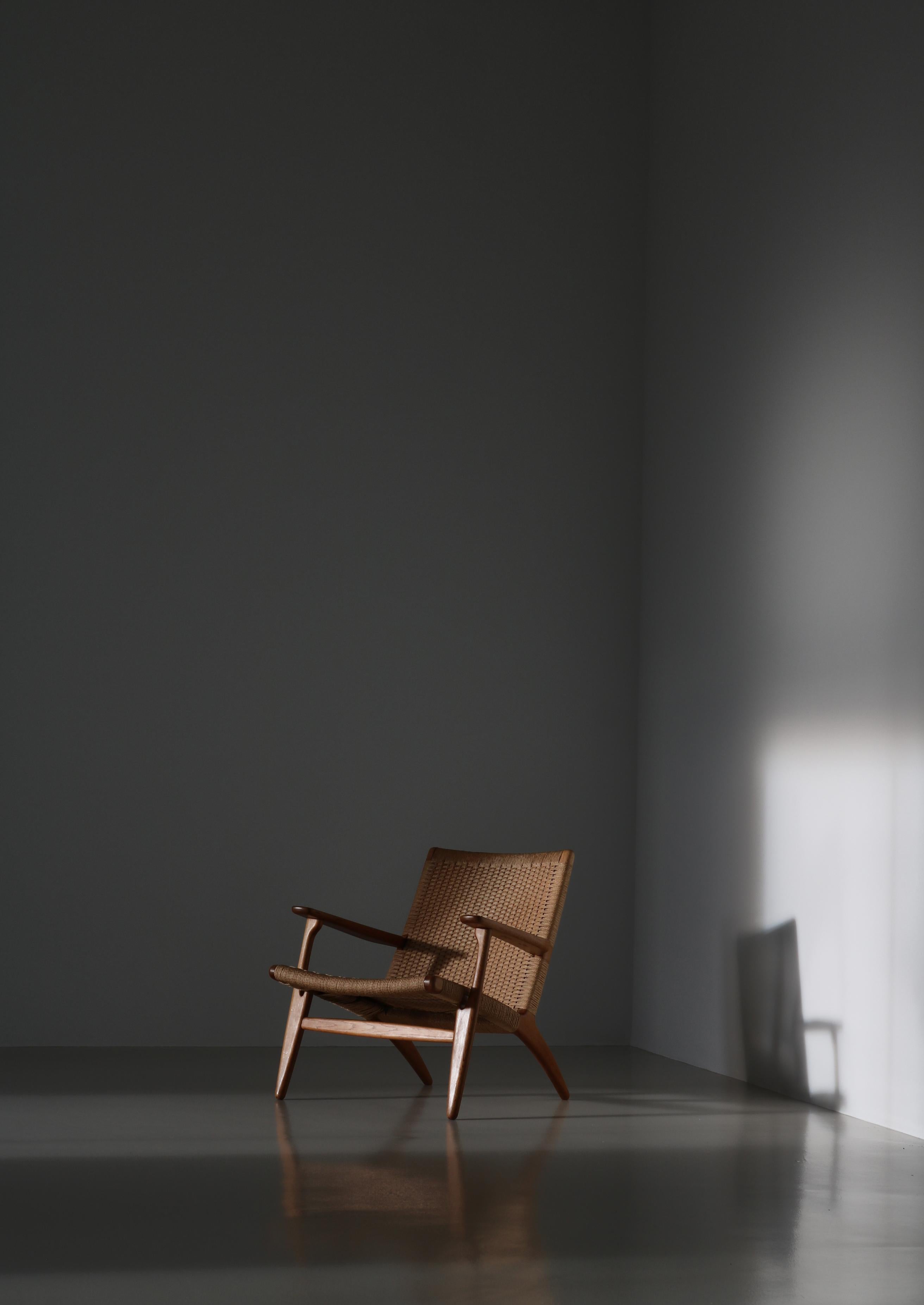Rare early edition lounge chair model CH25 by Danish designer Hans J. Wegner for Carl Hansen & Son in oakwood and woven paper cord. The CH25 is one of the first four chairs Hans J. Wegner created for Carl Hansen & Søn at the beginning of the