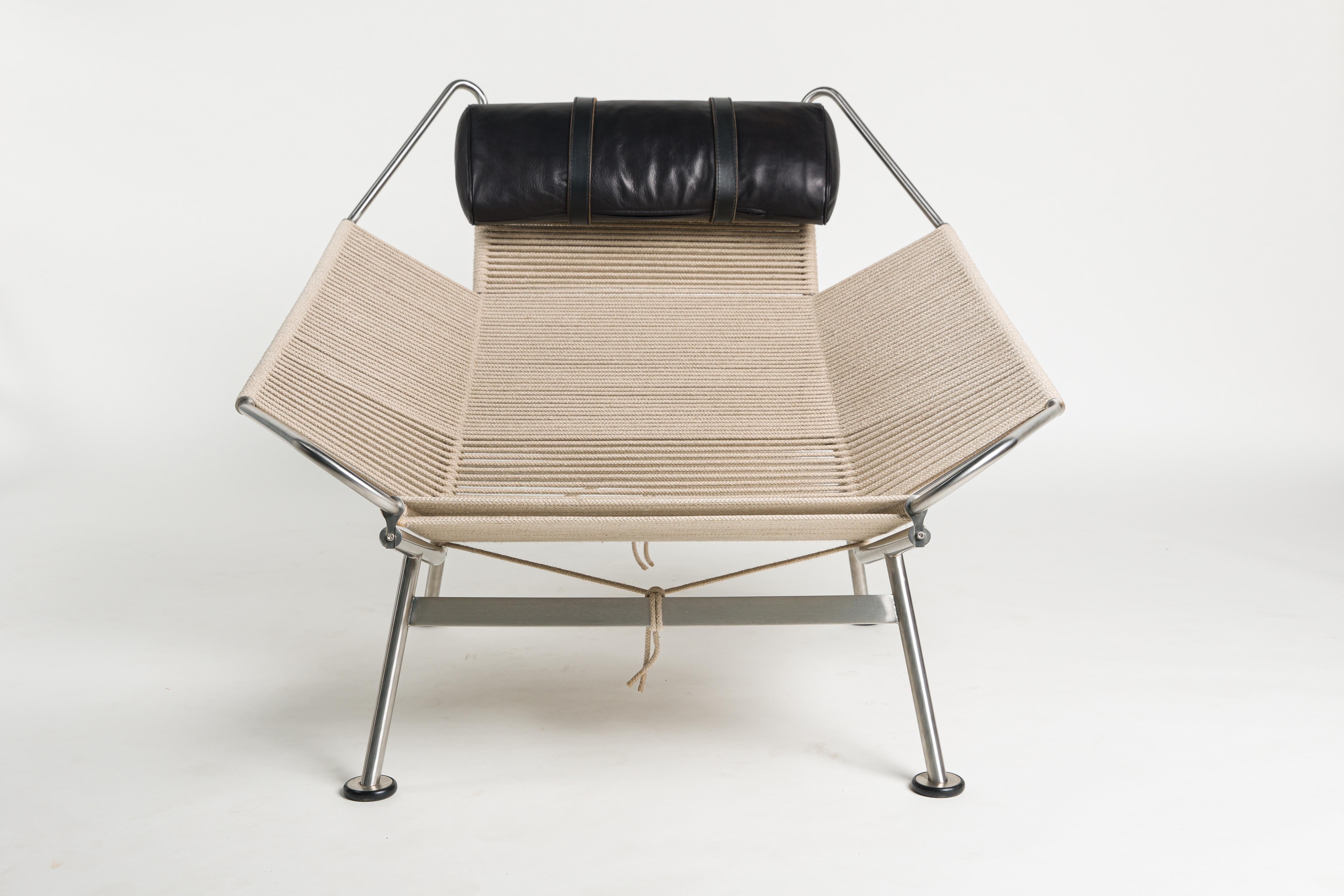 Flag Halyard chair by Hans J. Wegner (1914 - 2007) with brushed steel frame.
Seat, back, headrest and armrest surfaces mounted with light-coloured flag halyard. Pillow with black Elegance leather. Accompanying long-haired sheepskin included.
