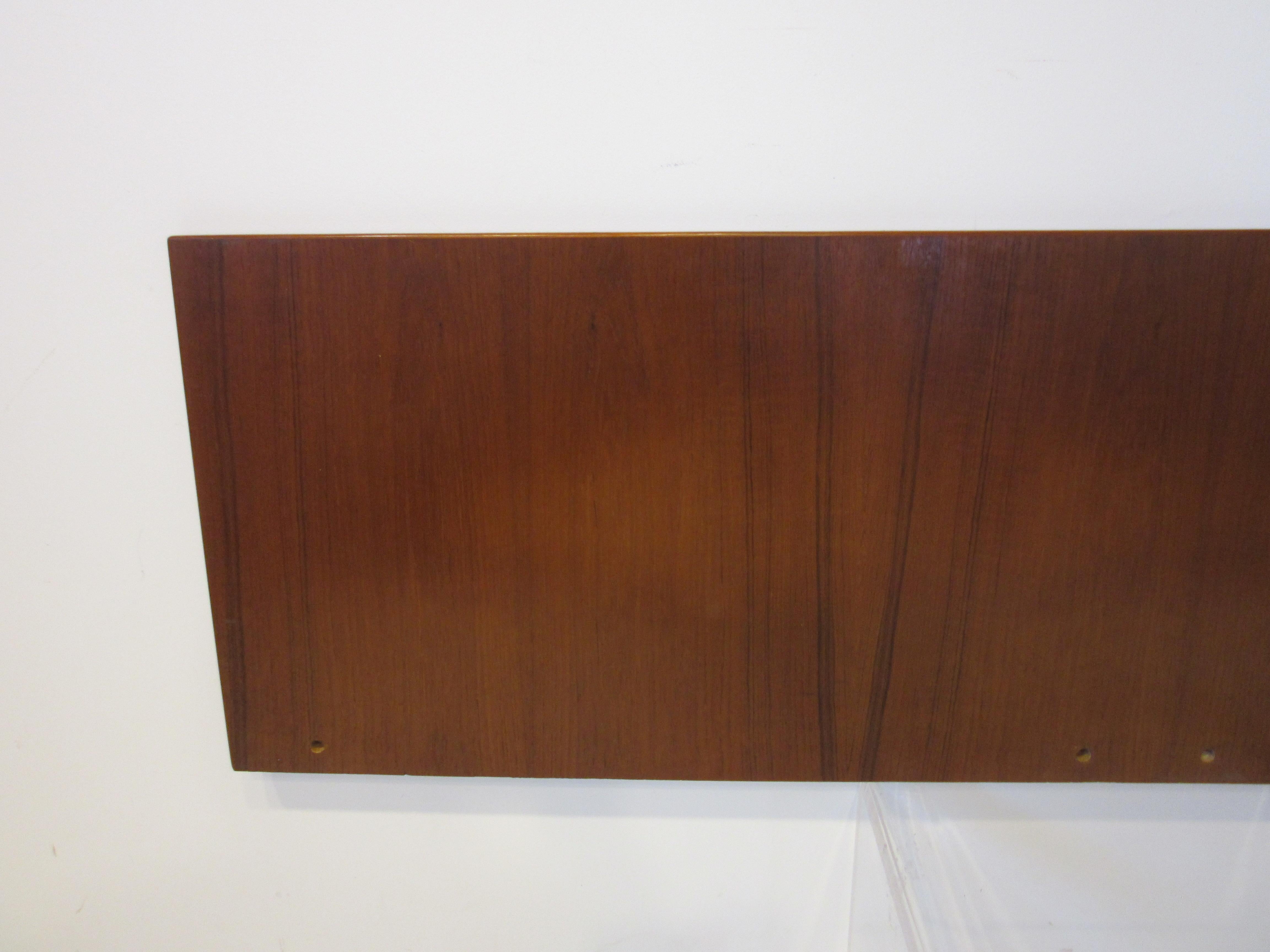 A wall mounted teak wood queen sized headboard with finished edges and a simple profile, branded to the back manufactured by GETAMA Gedsted Denmark Designed by Hans Wegner . There is no mounting hardware included you or your carpenter would have to