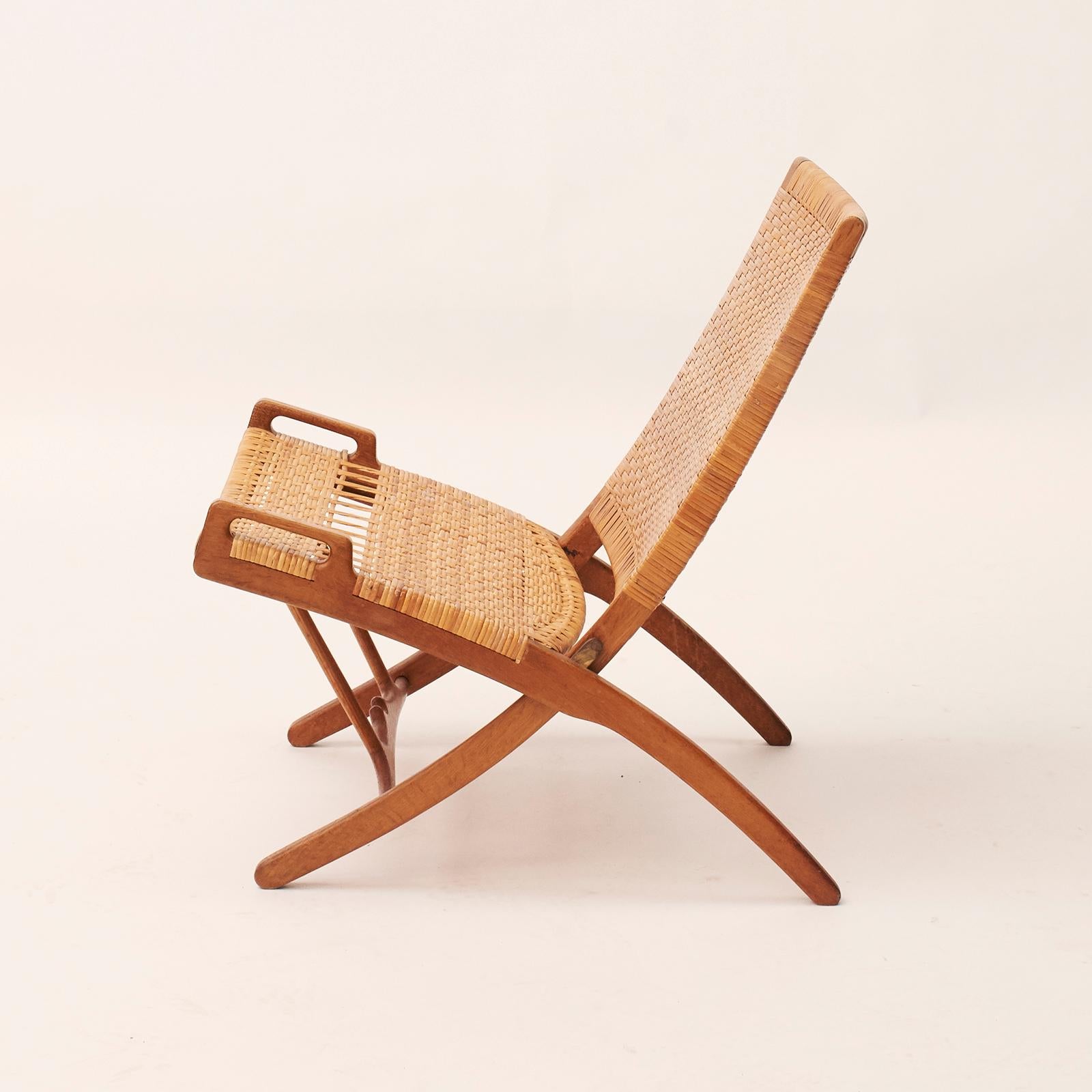 Hans J. Wegner 1914-2007. Model HJ512, 'Kaminstol'. Folding chair in oak, woven cane seat and back. Designed in 1949. Produced by Johannes Hansen, Model JH-512.
The model was presented at The Copenhagen Cabinetmakers’ Guild Exhibition at