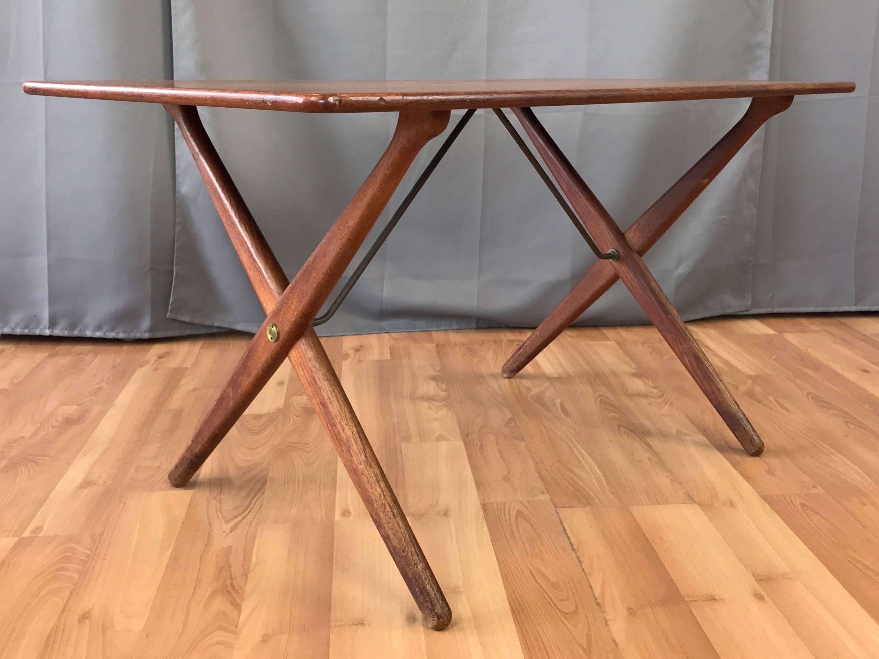 A model AT-308 all teak coffee or cocktail table by Hans J. Wegner for Andreas Tuck. 

Designed in 1955, this table is typically found with a teak top and oak base, which makes this all teak example quite uncommon. Distinguished by an elegant pair