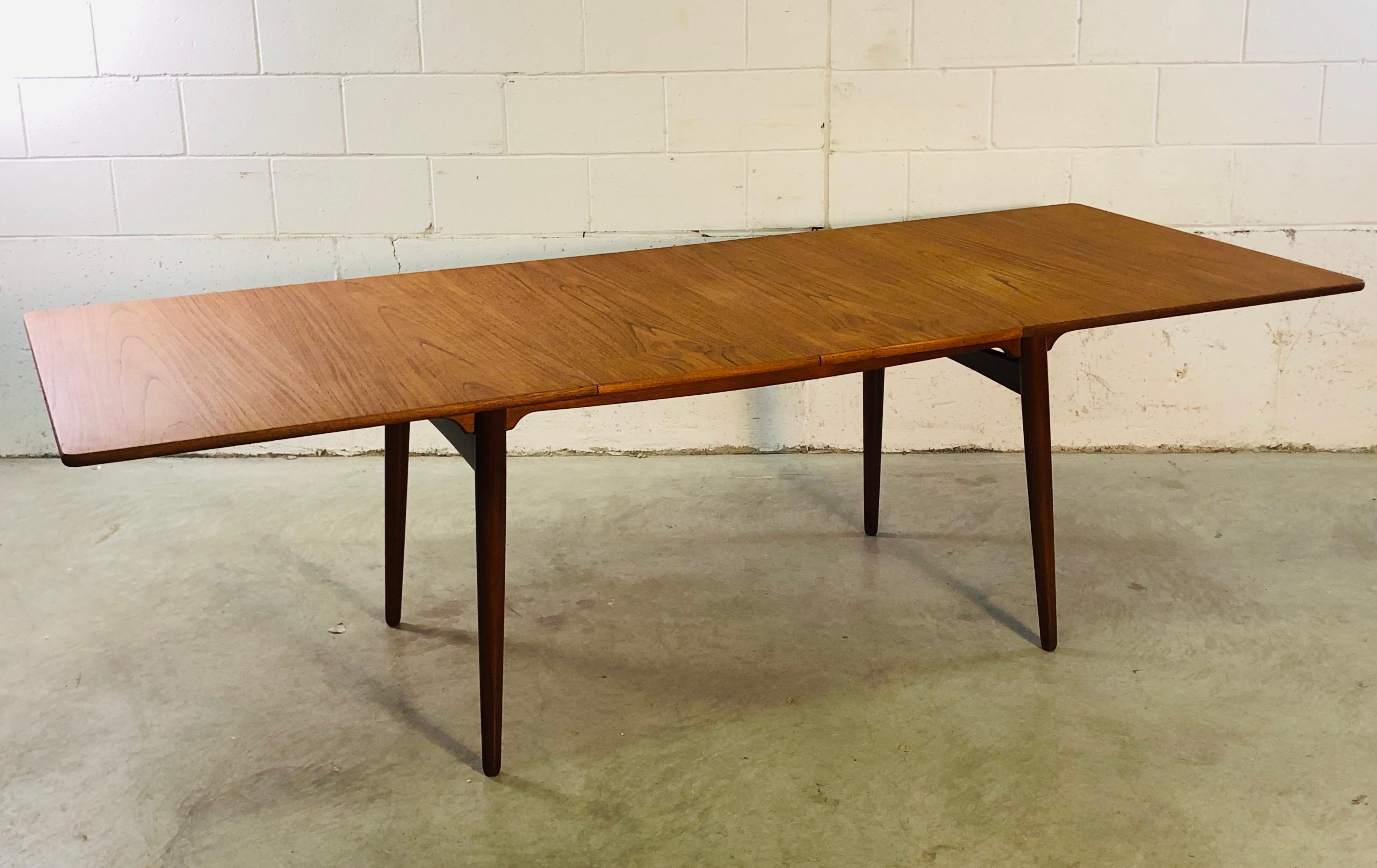 Vintage Danish teak dining room table designed by Hans J. Wegner for Andreas Tuck. This table model is AT-310. The table comes with two extra boards, each 15.75” L. Fully opened the table is 94” L. Marked underneath. Refinished condition.