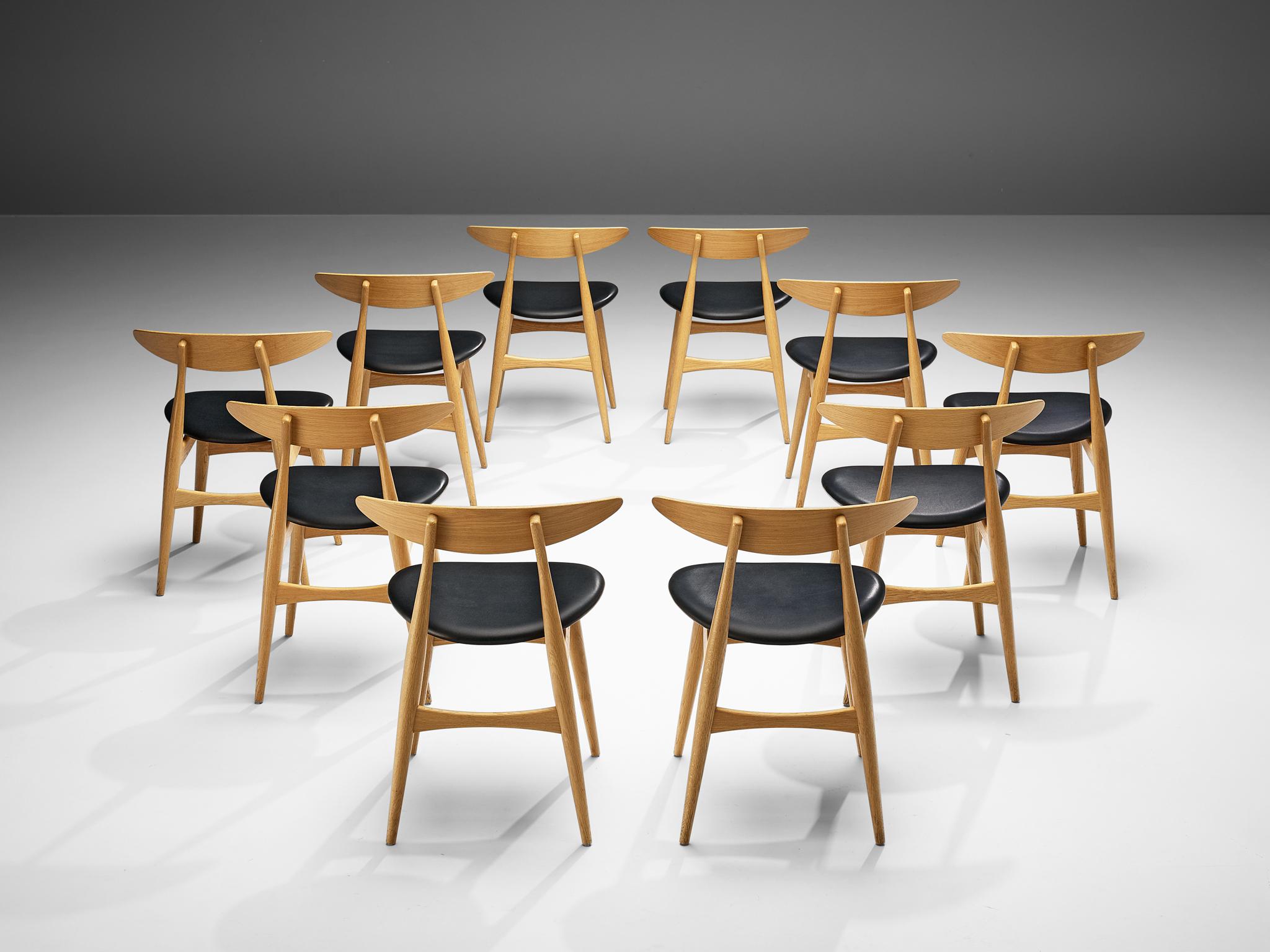 Hans J. Wegner for Carl Hansen & Søn, set of ten dining chairs, model 'CH 33', oak, leather, Denmark, design 1954, later production. 

Set of ten dining chairs designed by Danish designer Hans J. Wegner. These chairs are upholstered in black
