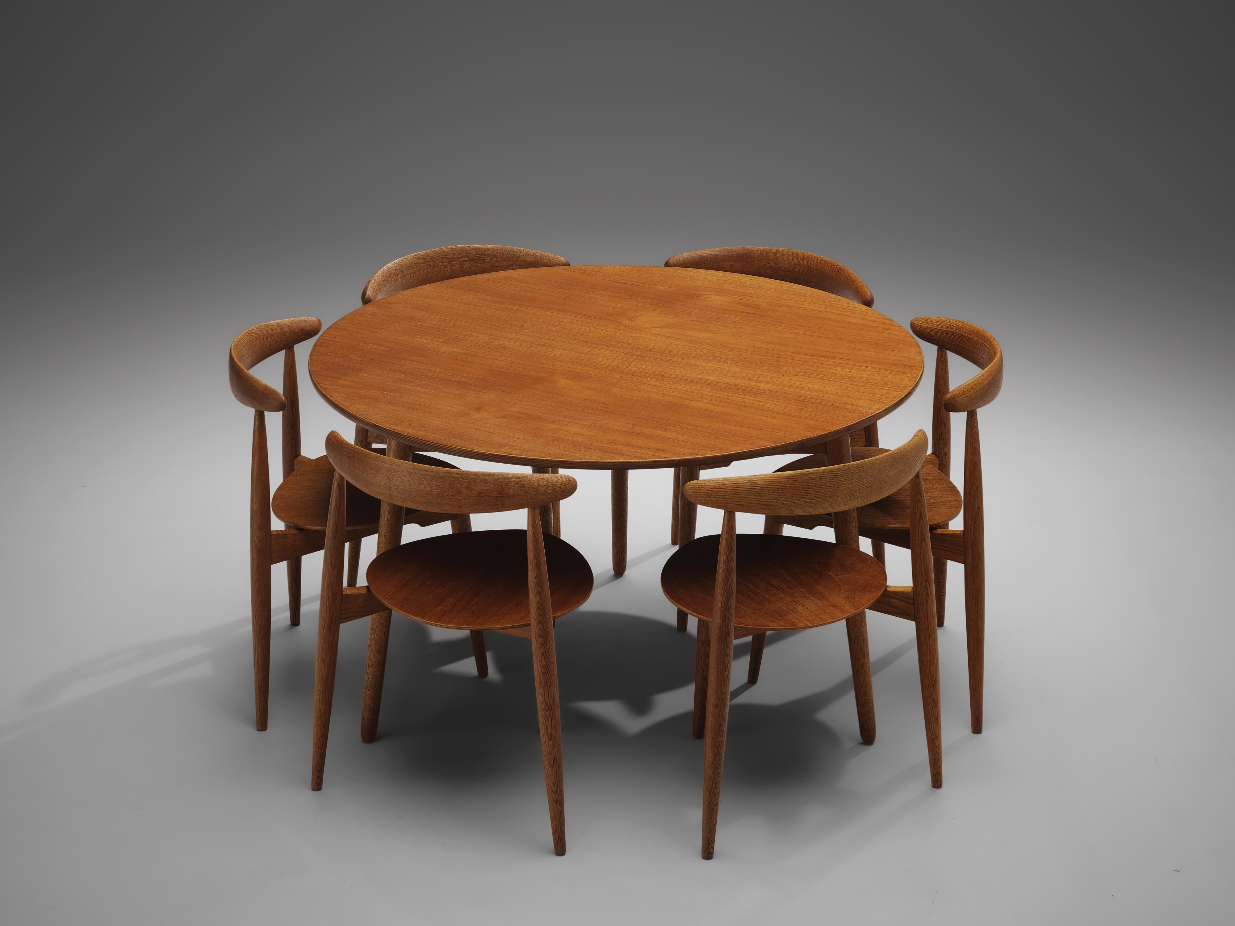Hans J. Wegner for Fritz Hansen, set of 6 'Heart’ chairs FH4103 and dining table, teak, oak, Denmark, 1953

This dining set, consisting of a round dining table and six dining chairs model FH4103, is designed by Hans Wegner in 1953. The chairs are