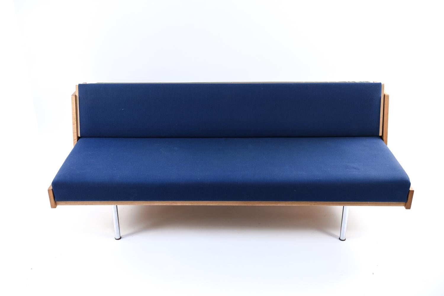 A Danish mid-century daybed designed by Hans J. Wegner for Getama, model GE258. This daybed has a frame of sturdy oak, with steel legs, and blue upholstery. This versatile daybed is the perfect place to relax or sit in style.