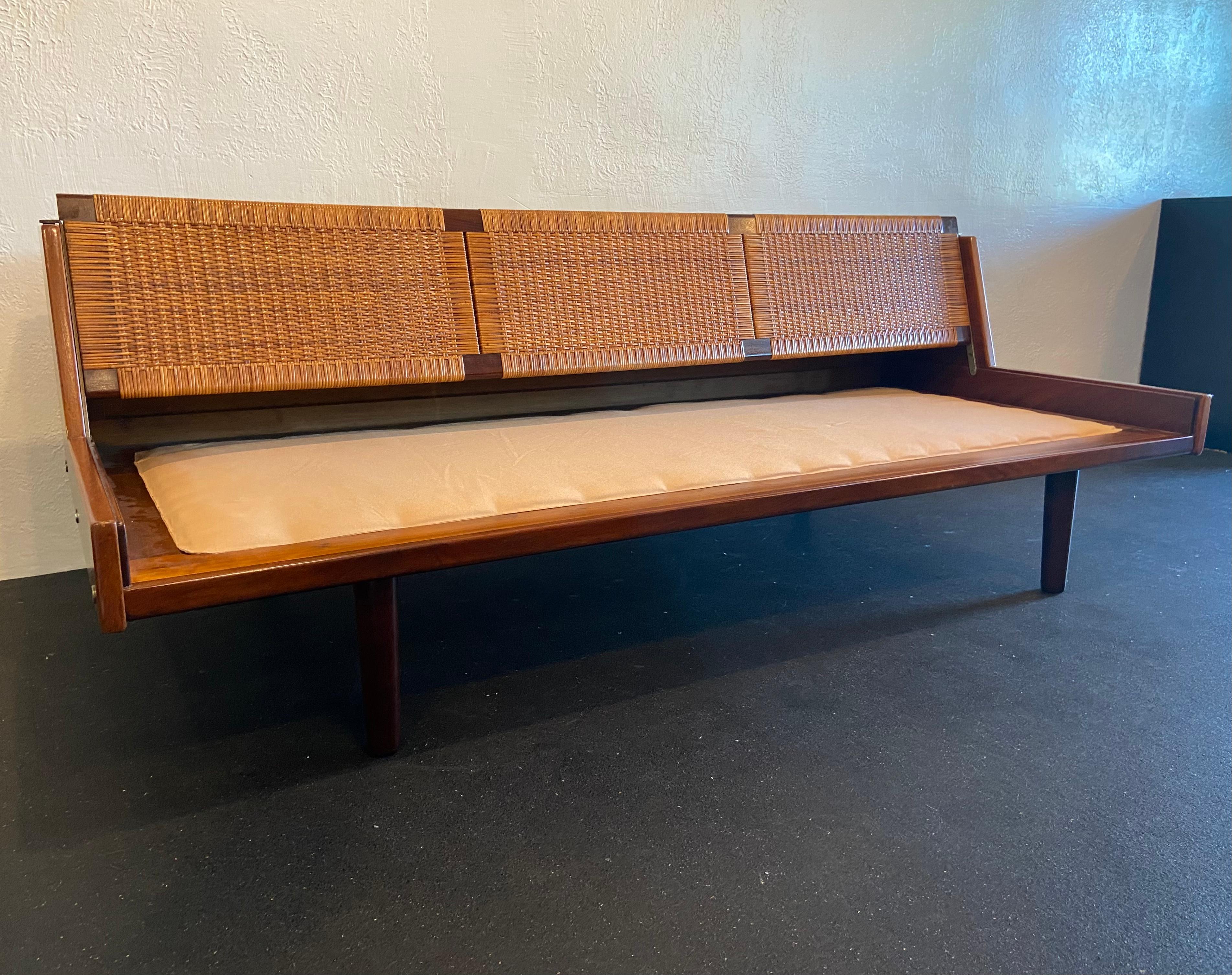 Hans J. Wegner for Getama GE-7 daybed. Rare walnut, teak and cane combination. Original leather cushion with warm patina. Daybed has been refinished. 

Would work well in a variety of interiors such as modern, mid century modern, Hollywood