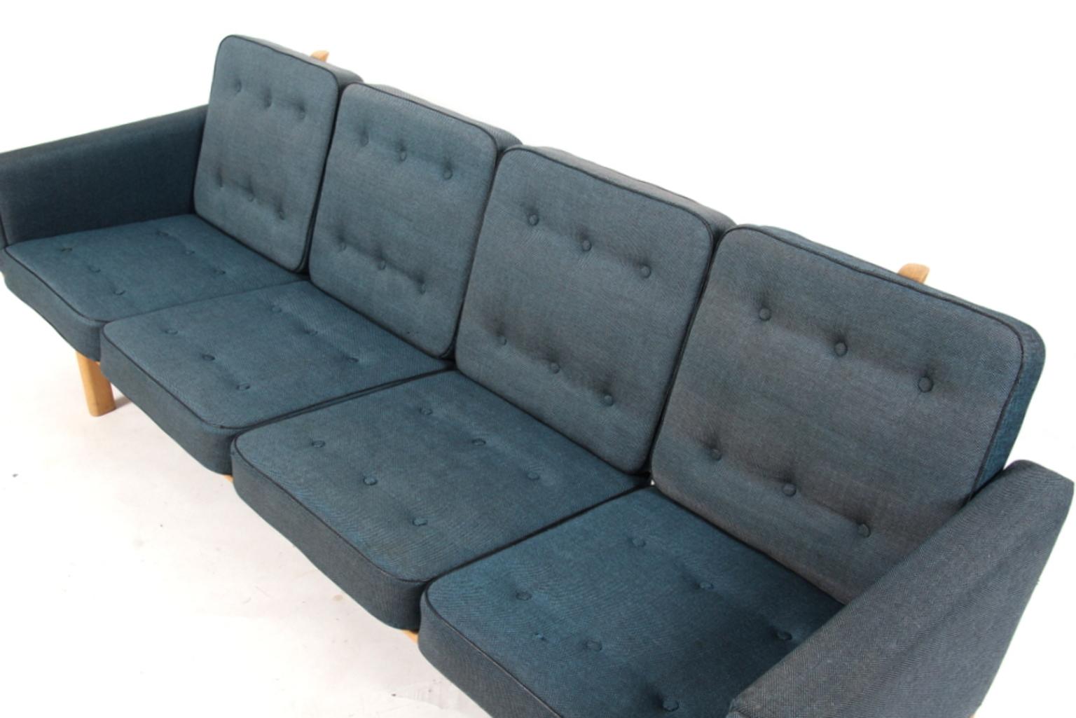 Hans J. Wegner four-seater sofa upholstered with blue and black flecked fabric with leather pipings.

Original Epeda cushions.

Frame in solid oak.

Model 236/4, produced by GETAMA.