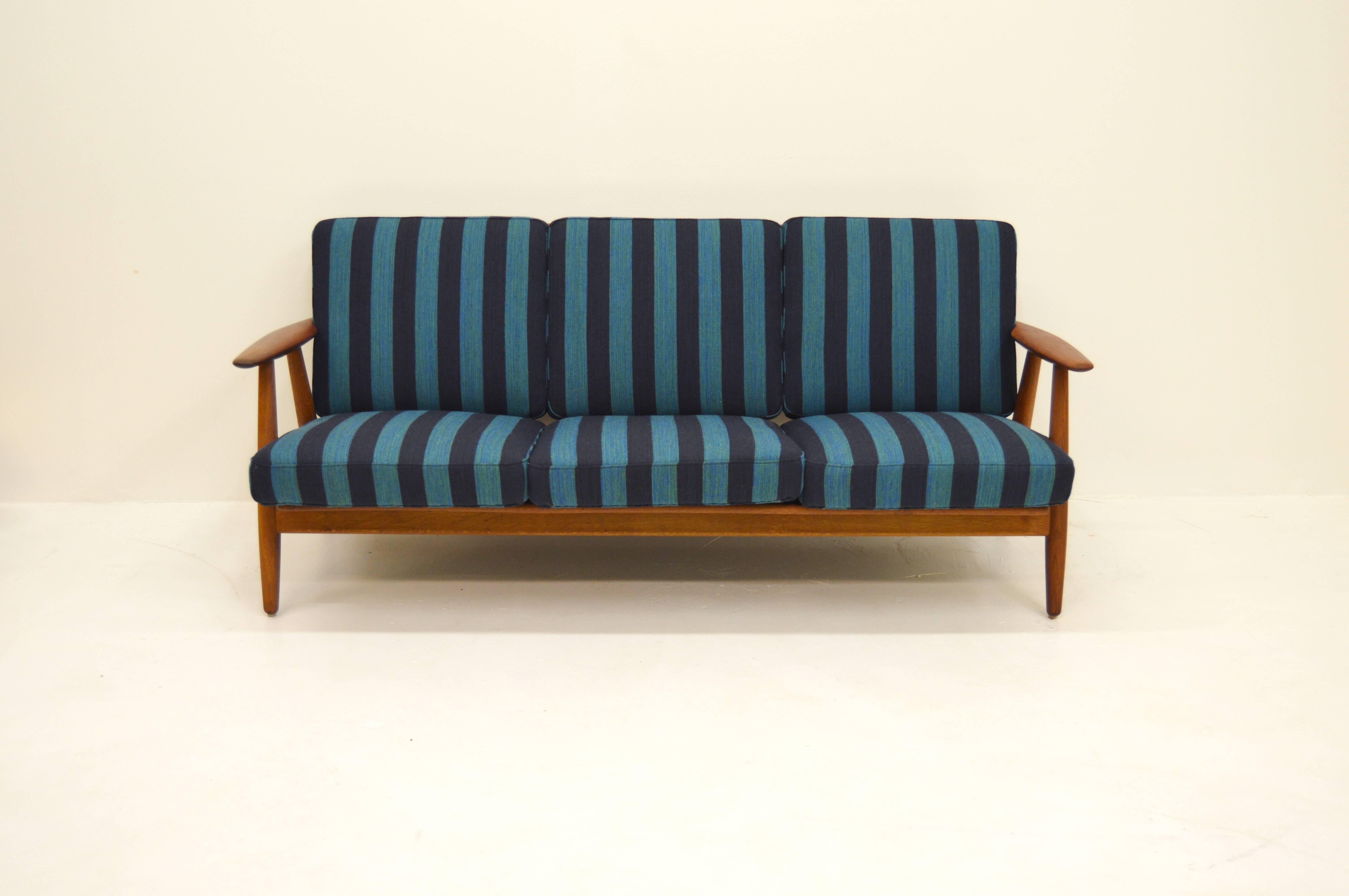 Sofa designed by Hans J Wegner for Getama. Model name GE 240.
Newly upholstered. 
Rare model with teak armrests and oak frame.