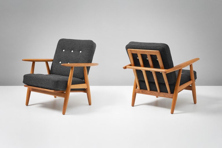 Hans J. Wegner

Pair of GE-240 'Cigar' chairs, 1955.

Produced by GETAMA, Gedsted, Denmark. Oak frames with original sprung cushions reupholstered in contrasting dark and light grey Kvadrat Hallingdal wool fabric. Maker's brand under