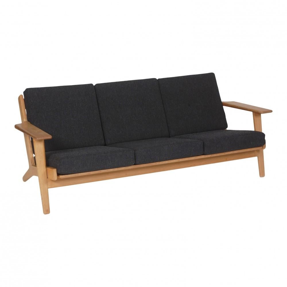 Hans J. Wegner 3.seater sofa model ge-290/3 with a frame of oak and cushions of grey fabric. Appears in good condition with some patina on the frame and cushions.