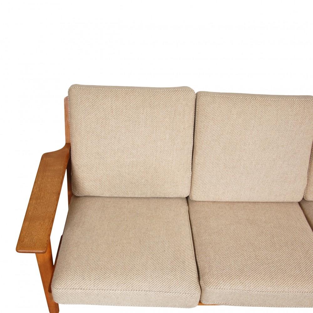 Hans J. Wegner Ge-290 3-seater sofa with frame of solid oak and original beige cushions. The frame appears in good condition with minimal traces of wear and cushions which are also in good condition, but with a few small stains.