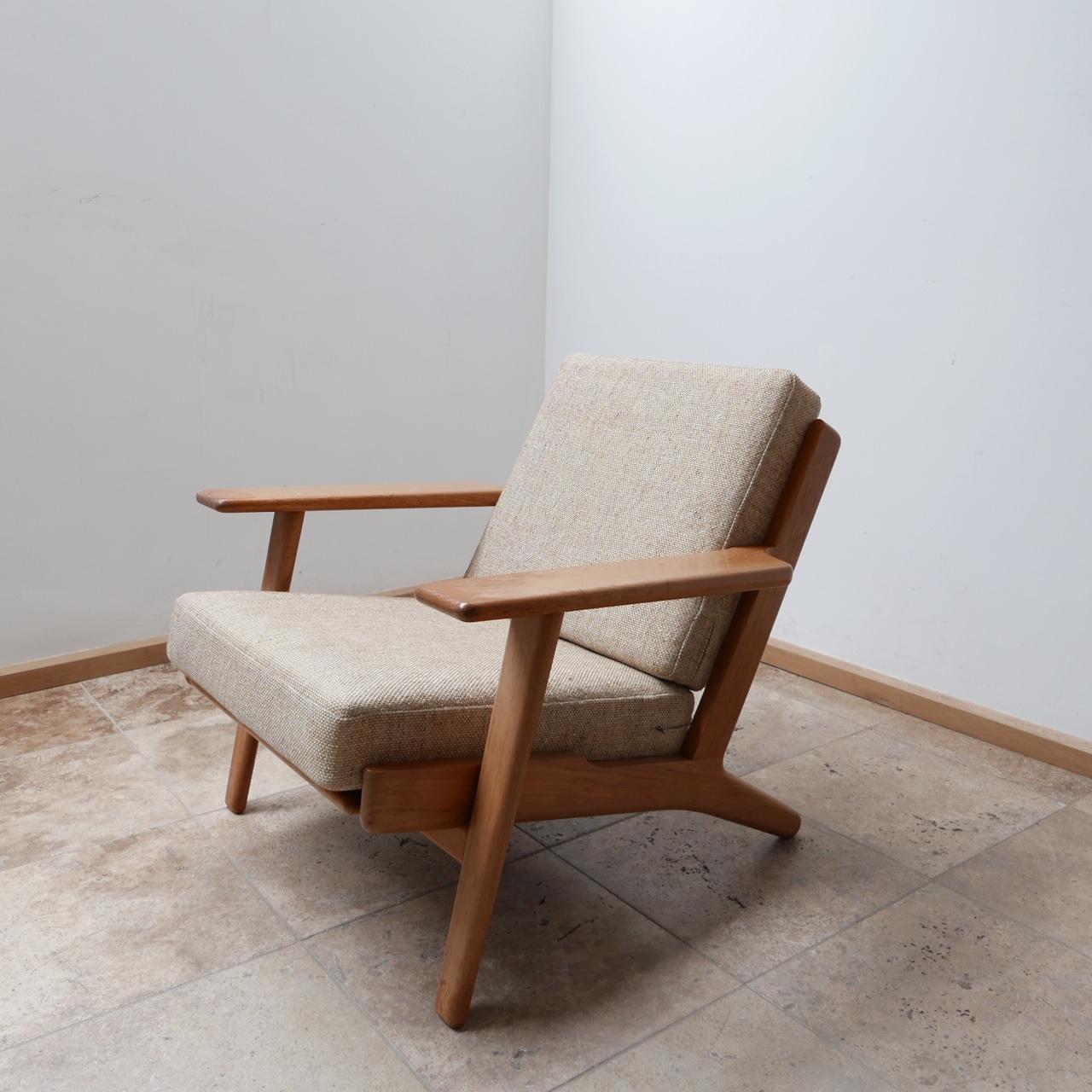 The much demanded GE 290 model armchair by design legend Hans J Wegner. 

Denmark, c1960s. 

Stamped Getama to underside, original cushions and chainlink straps retained. Cushions are in good condition. 

Some wear to the wood finish which