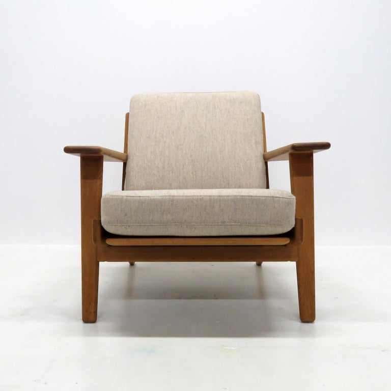 Wonderful lounge chair GE-290, designed by Hans J. Wegner for GETAMA in 1953, solid oak frame with nice patina and upholstered in speckled gray wool on original spring cushions, marked.