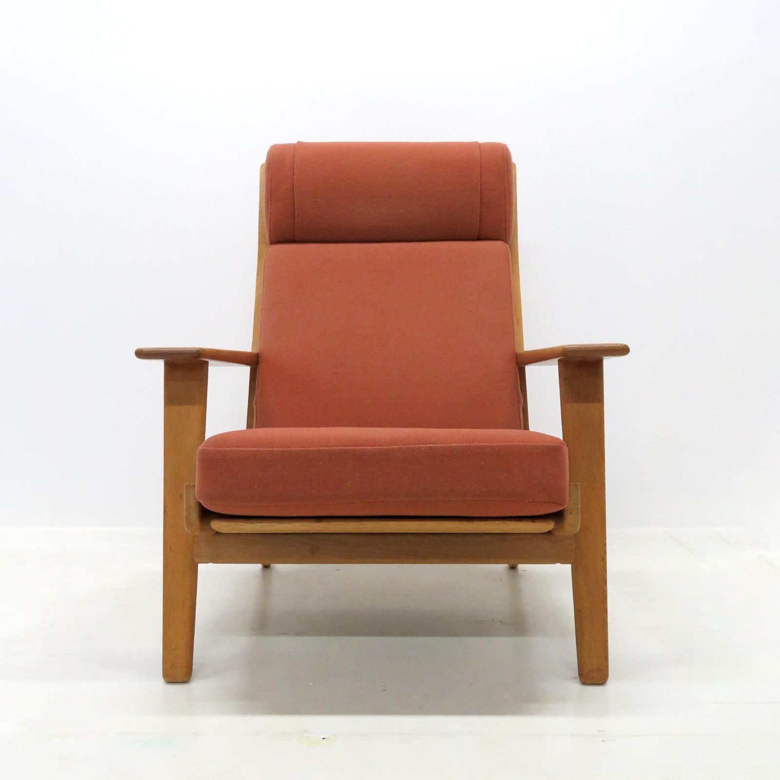 Wonderful high back lounge chair GE290A by Hans J Wegner for GETAMA, solid oak frame with nice patina and original cushions in light maroon wool fabric, marked.