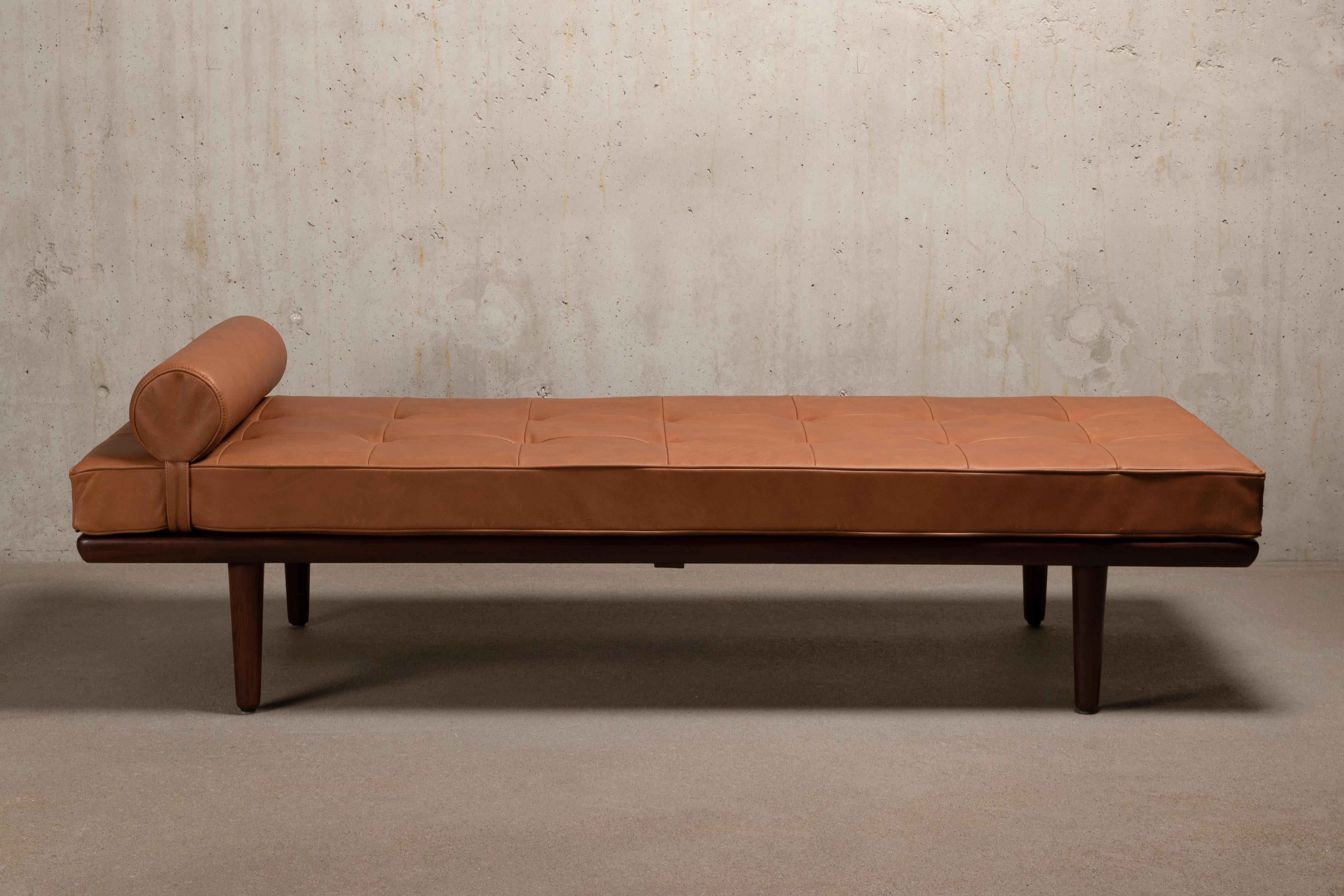 Great daybed Model GE19, designed by Hans Hans J. Wegner for GETAMA Denmark in 1956. Teak frame and tapered legs in good condition with minor traces of use. New mattress and neck roll pillow upholstered in beautiful high quality soft Cognac