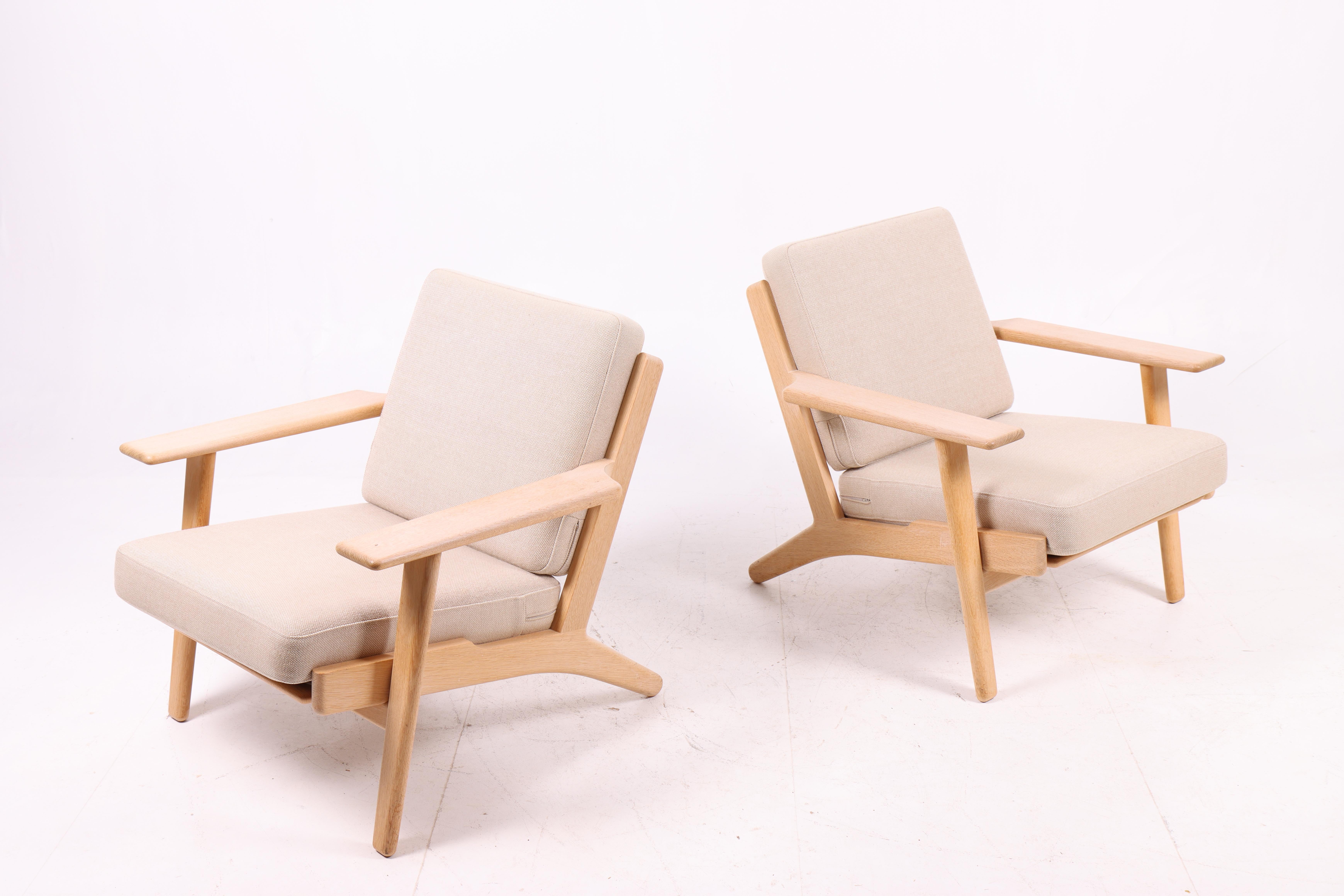 A pair of iconic GE290 lounge chairs designed by Hans J. Wegner and produced by Getama in Denmark during the 1970s. Crafted in solid oak with Wegner’s characteristic angled frame and wide armrests, the chairs embody both comfort and sculptural