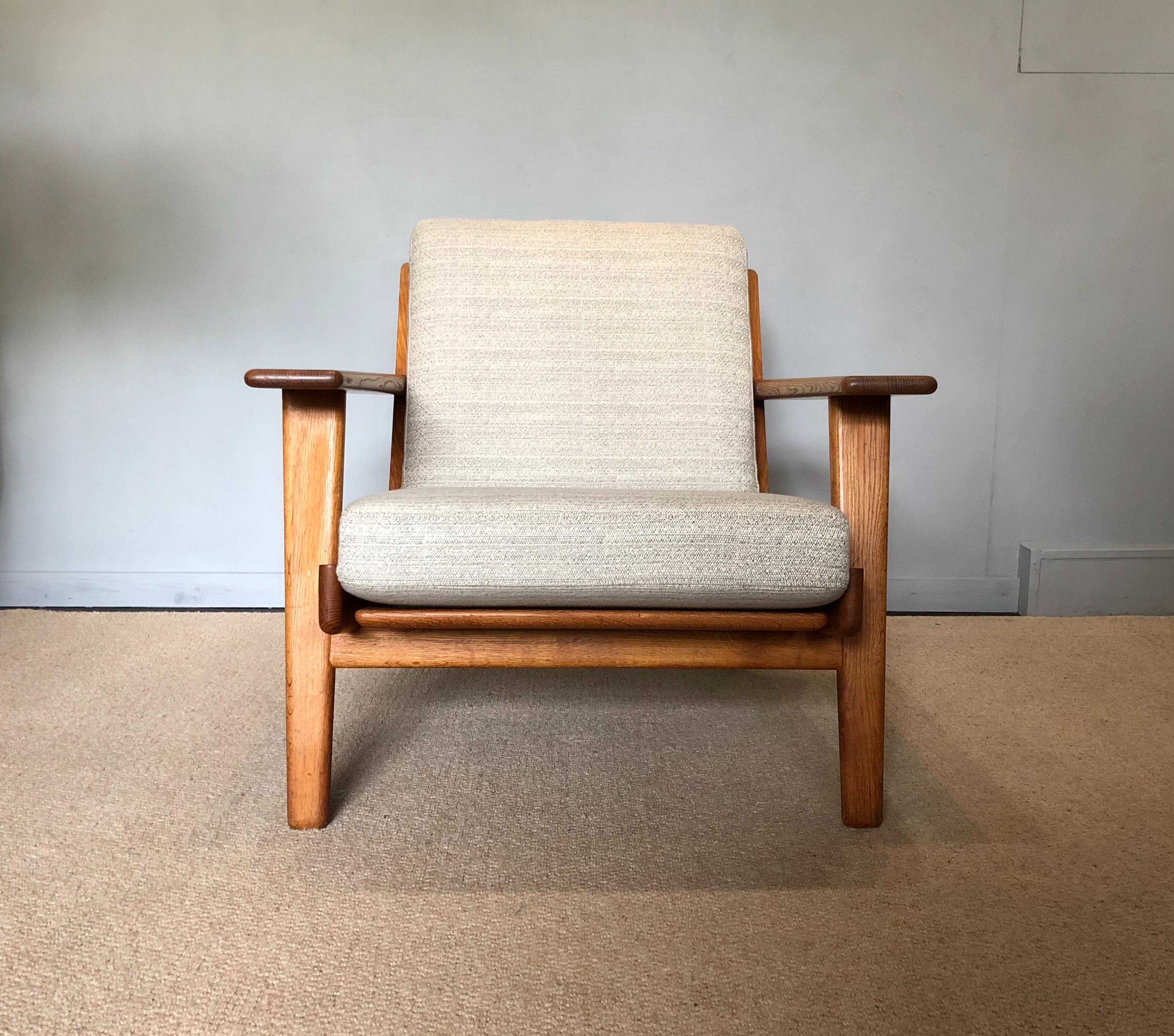 A wonderful original example of the Hans J Wegner ge290 lounge chair. This early model was produced by Getama, Denmark, circa 1950. Golden European oak frame with new Dedar fabric reupholstery. Otherwise known as the plank chair this is one of Hans