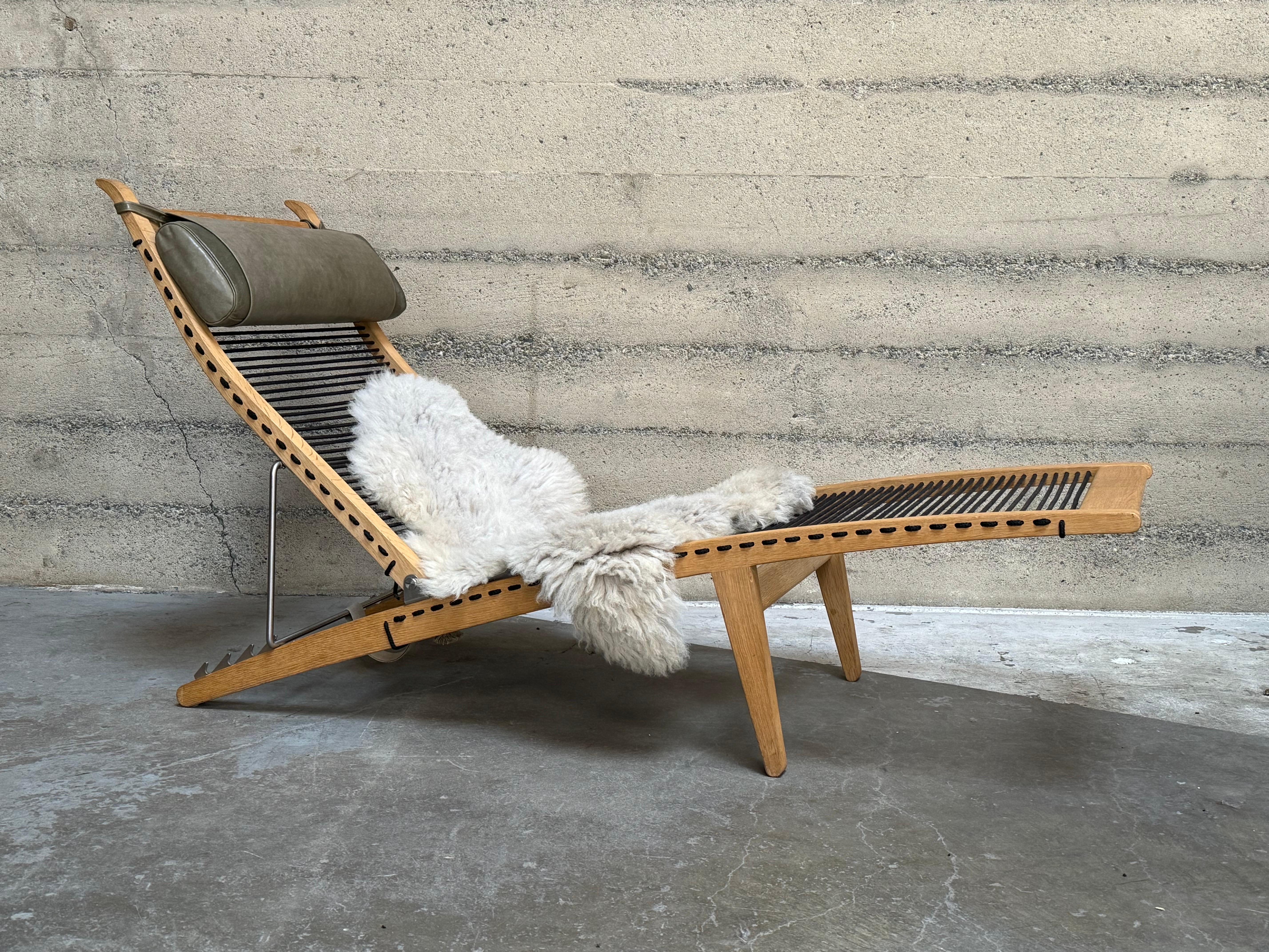 A classic deckchair designed by Hans J. Wegner in the 1950s, currently produced to-order by PP Møbler in Denmark. This example dates to the mid-2000s. 

The frame is constructed of solid white oak, the seat is woven in black cotton halyard rope and