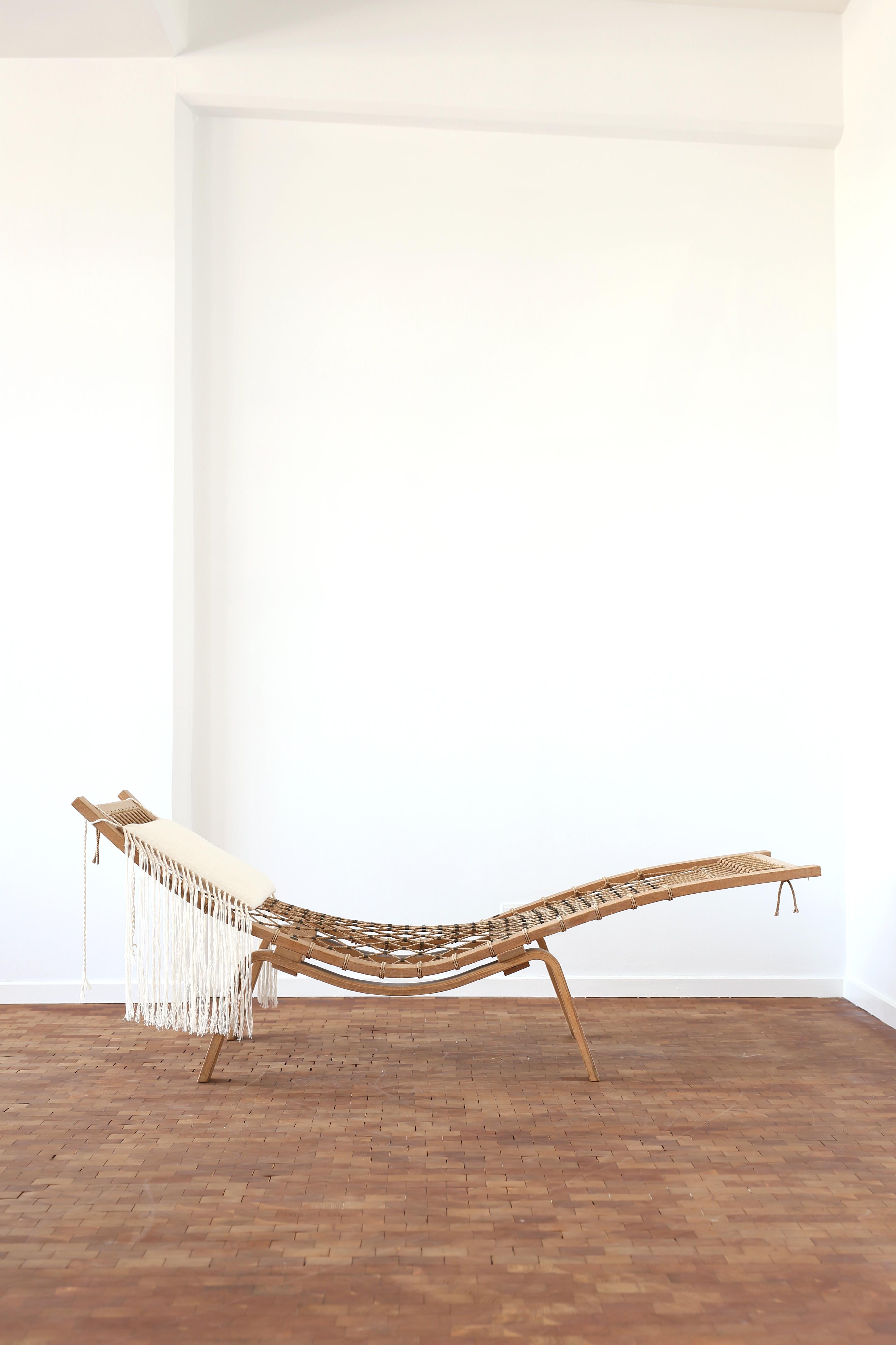 A rare Hans J. Wegner Hammock chaise lounge. 

Beautiful patinated oak frame and original halyard with copper details. 
Light linen fabric cushion with fringes. 

Designed by Hans J. Wegner, 1967 and made by Getama, Denmark. 

A pair is available. 