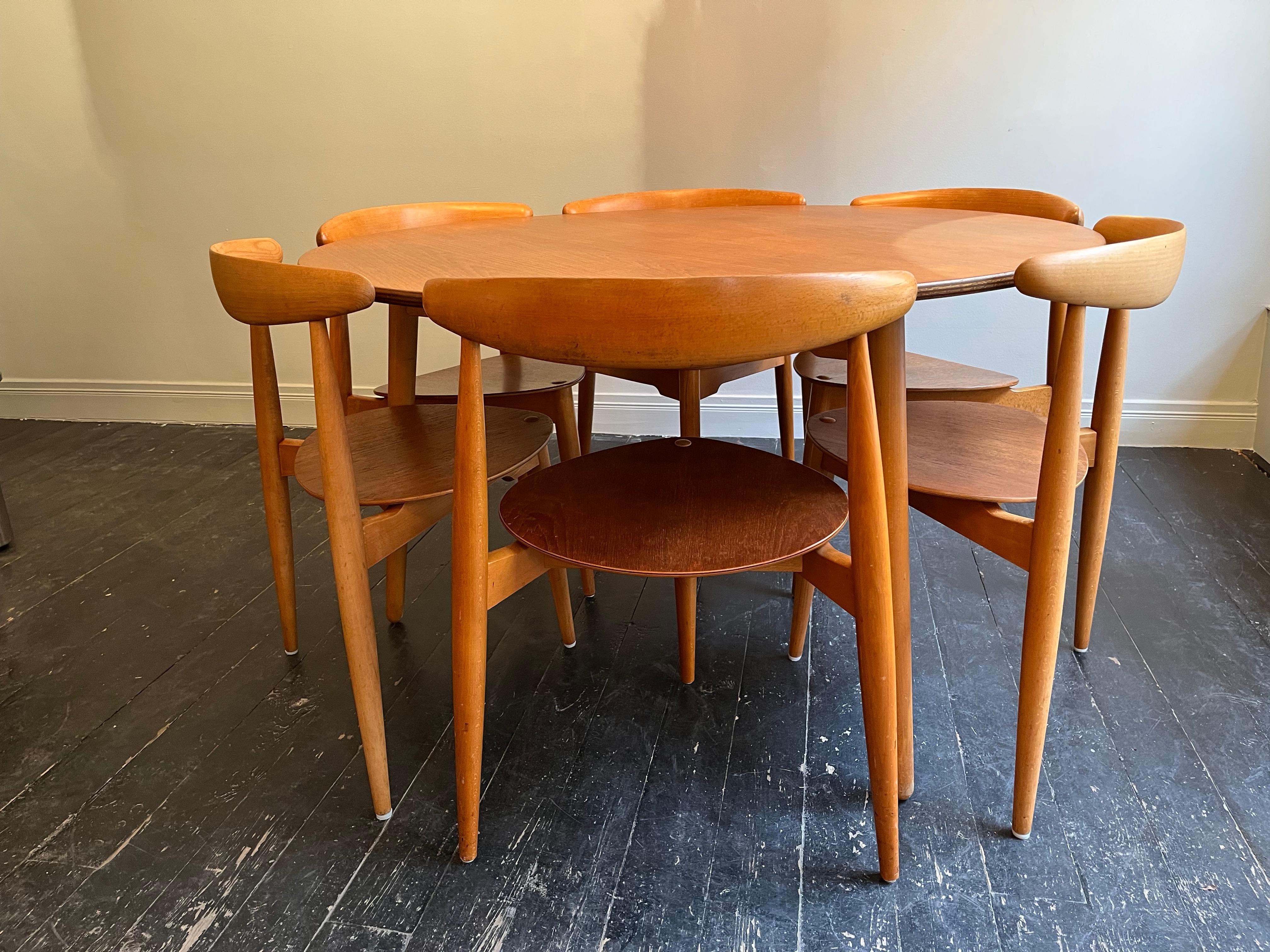 A very hard to find compact dining set designed in the early 50’s by Hans Wegner and produced by Fritz Hansen, Denmark.

The set of six Beech and Teak chairs sit flush beneath the table, this is both practical and aesthetically beautiful creating