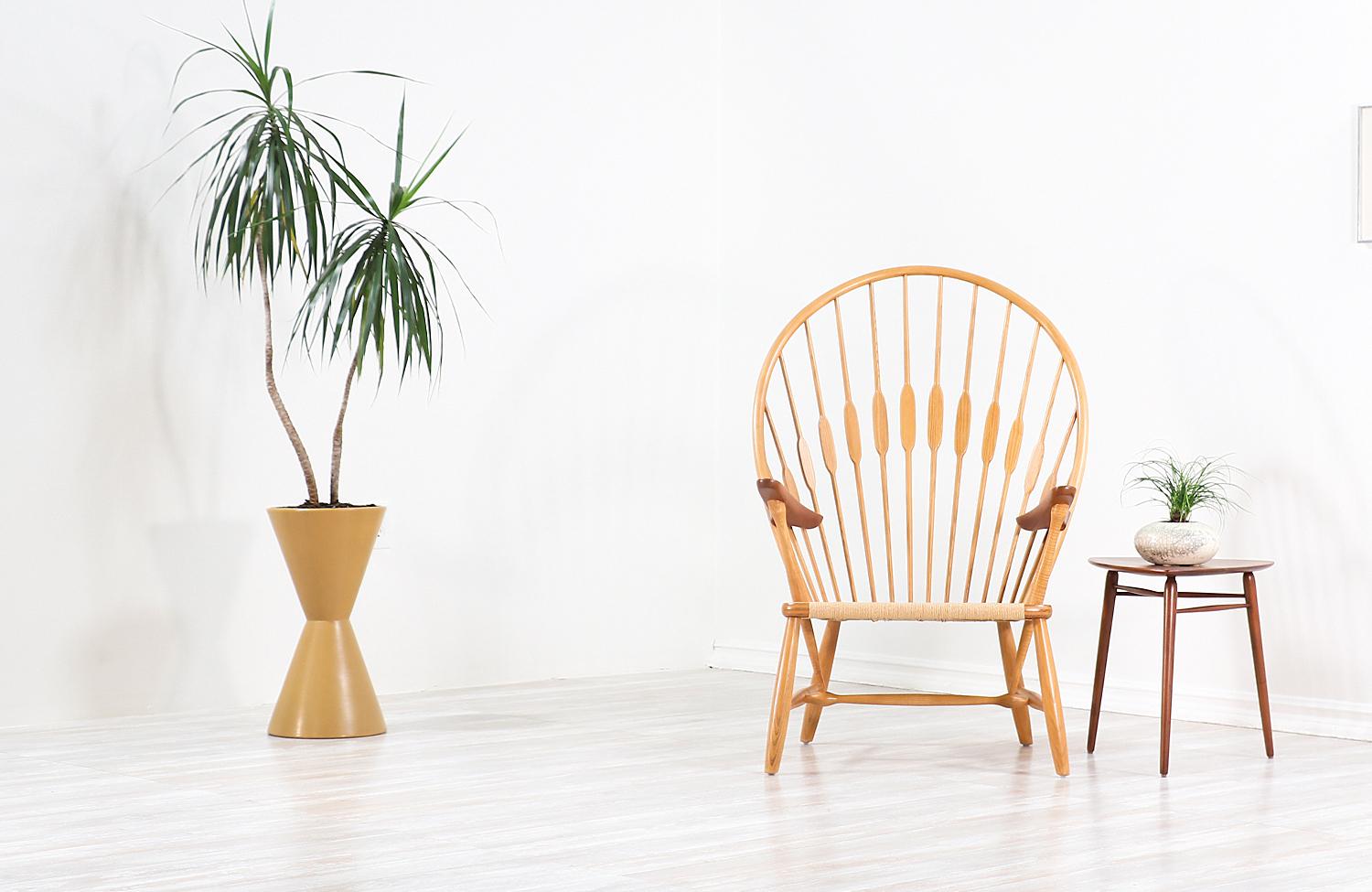 Iconic ‘Peacock’ chair model JH-550 designed by architect and designer Hans J. Wegner in 1947 and produced by cabinet maker Johannes Hansen in Denmark. Inspired by a traditional English Windsor chair, the peacock chair is one of Wegner’s finest