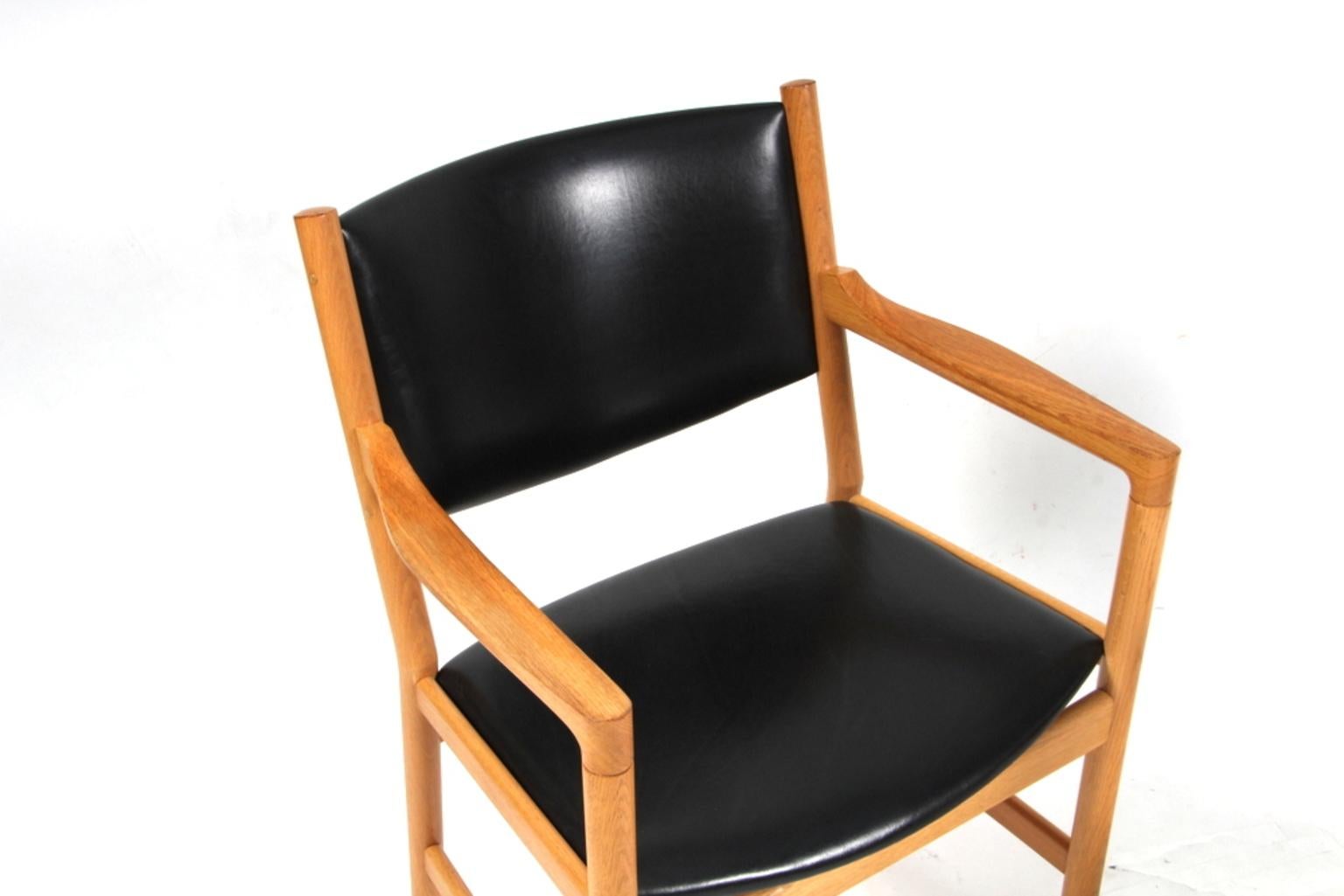 Hans J. Wegner lounge / arm chair in massive oak.

Seat and back upholstered with black aniline leather.

Model JH 872, made by Johannes Hansen. 

This is a very rare model but with Wegner's classic design.