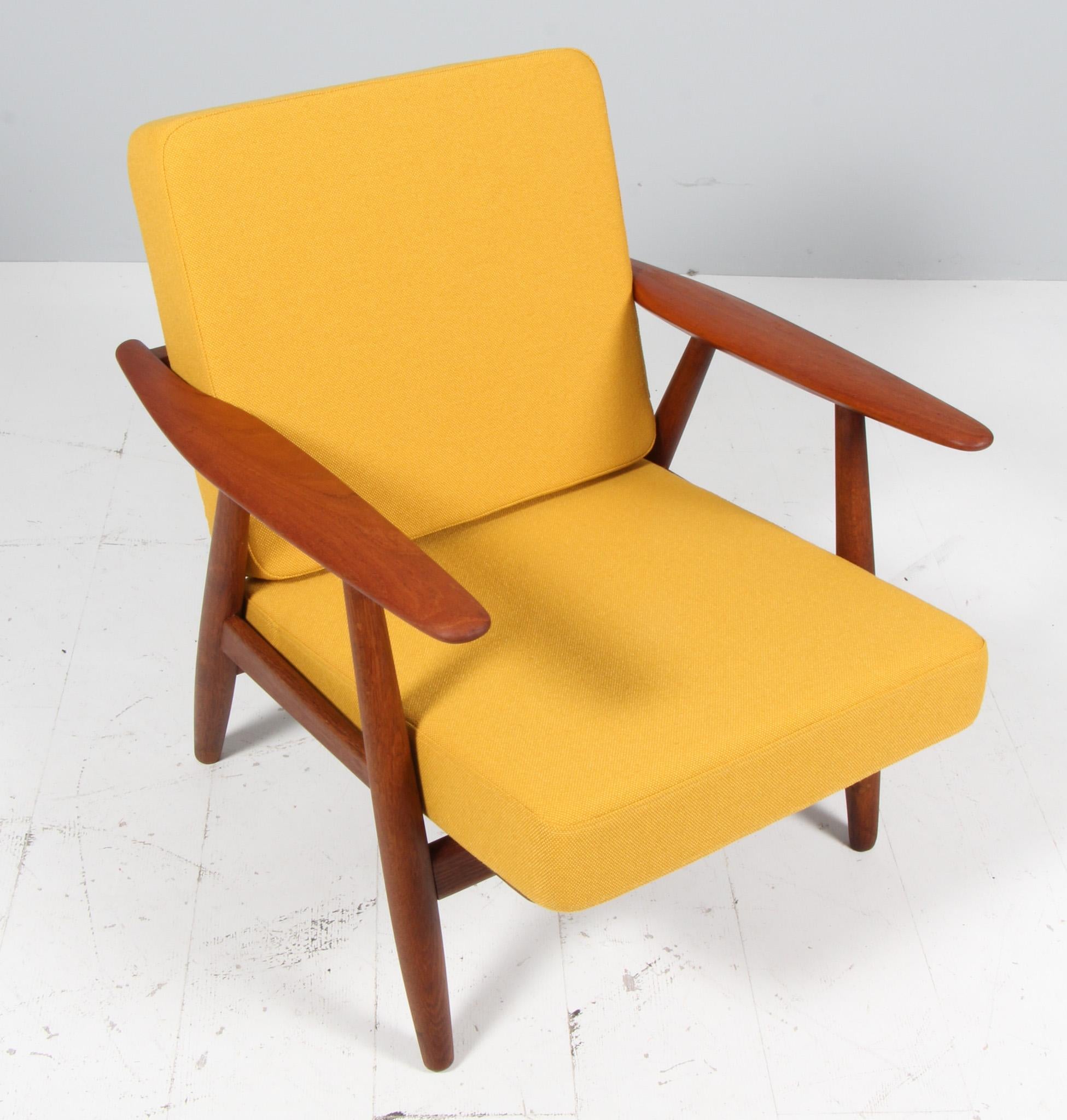 Hans J. Wegner lounge chair made of oiled oak and teak armrests.

New upholstered with yellow fabric.

Model 240 Cigar, made by GETAMA.

