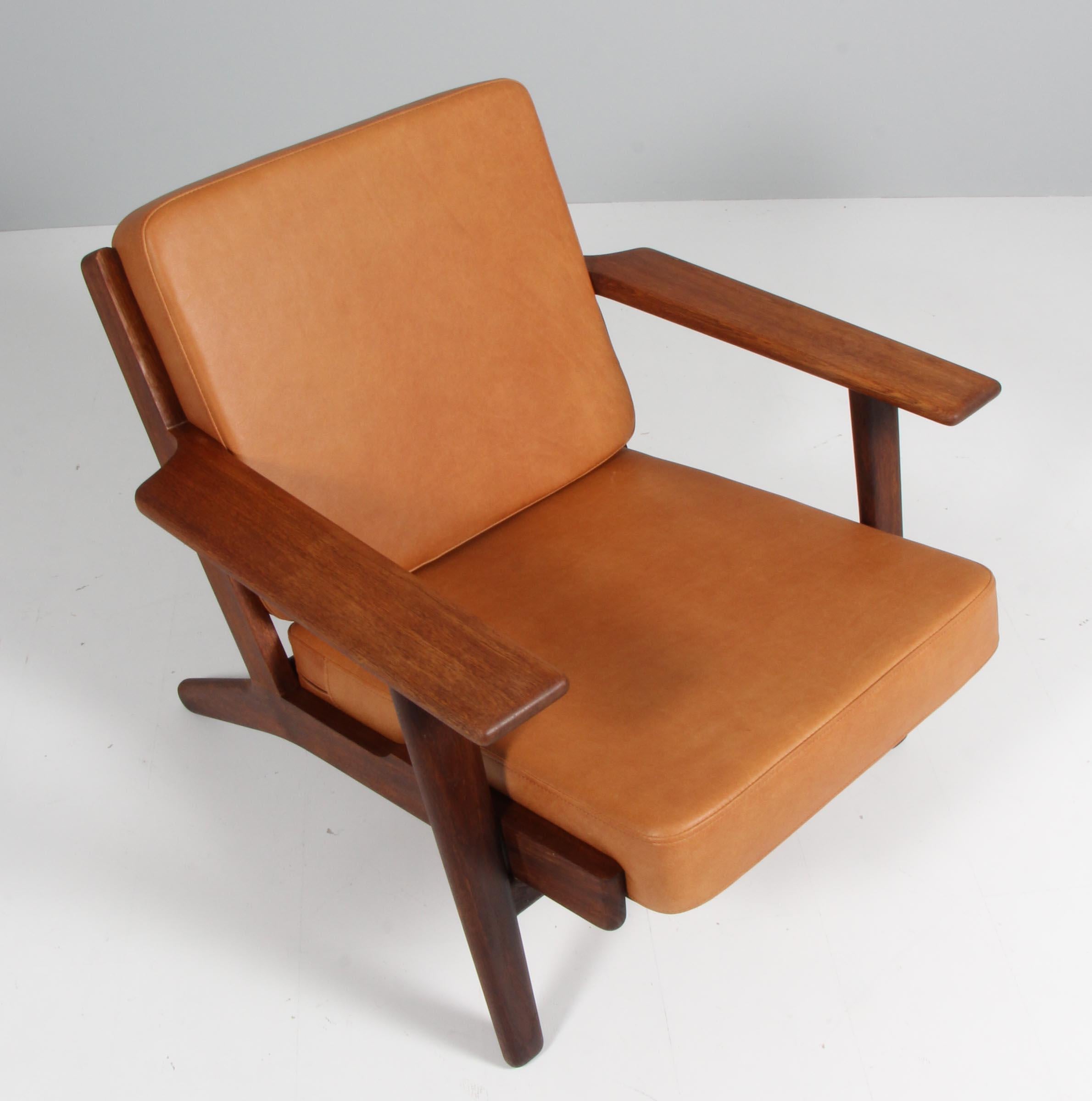 Hans J. Wegner lounge chair made of solid smoked oak.

New upholstered with vintage tan aniline leather.

Model 290, made by GETAMA.


