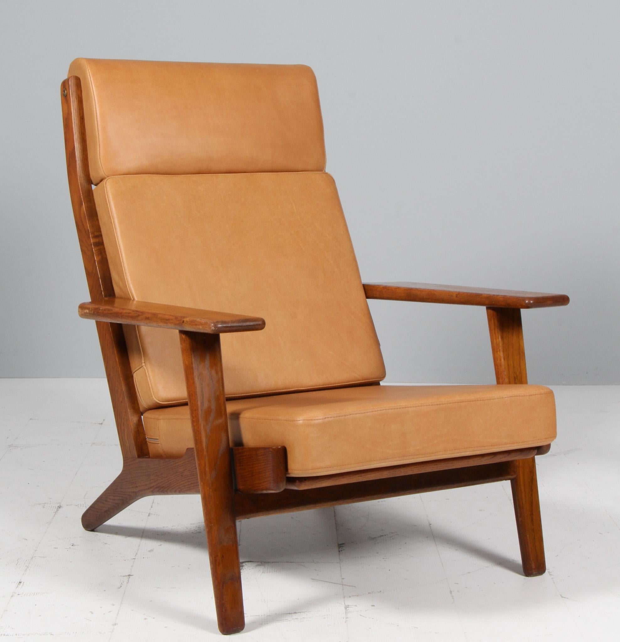 Hans J. Wegner lounge chair made of solid smoked oak.

New upholstered with vintage tan aniline leather.

Model 290A, made by GETAMA.

