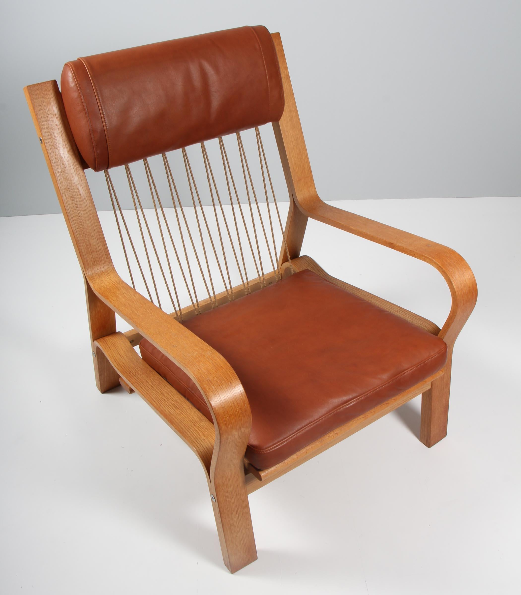 Hans J. Wegner lounge chair made bended oak veener. Cotton cord in back

New upholstered with brandy coloured aniline leather.

Model 671, made by GETAMA.

 