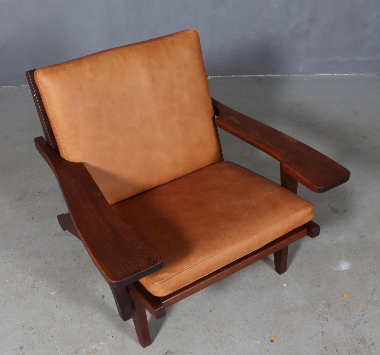 Hans J. Wegner lounge chair with loose cushions new upholstered with tan aniline leather.

Frame of smoked oak. With armrests.

Model GE-370, made by GETAMA.