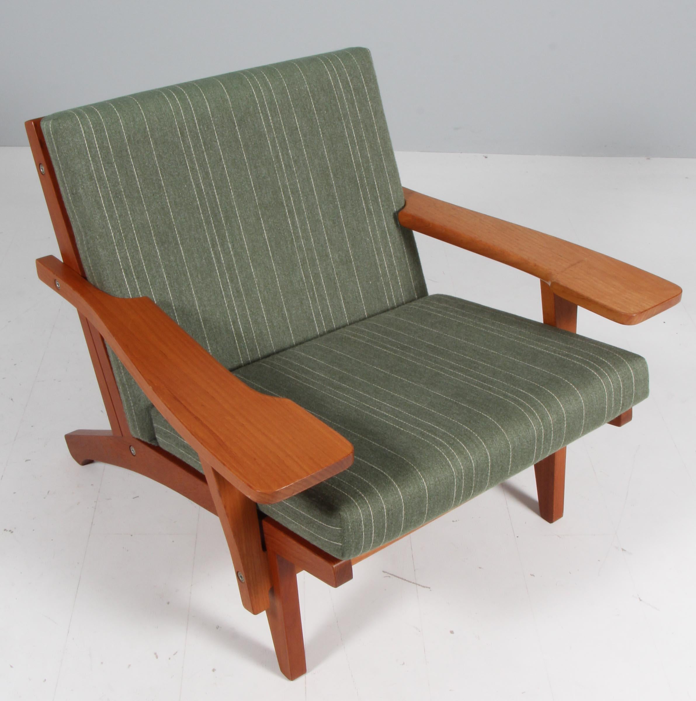 Hans J. Wegner lounge chair with loose cushions upholstered with green savak wool.

Frame of teak. With armrests.

Model GE-370, made by GETAMA.