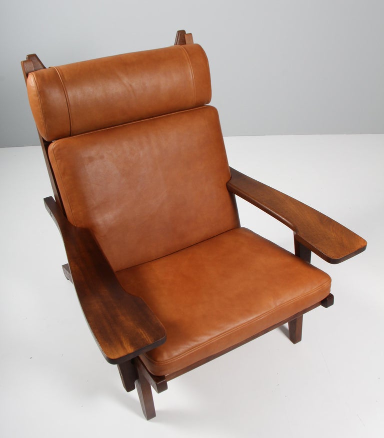 Hans J. Wegner lounge chair with loose cushions new upholstered with tan aniline leather.

Frame of smoked oak. With armrests.

Model GE-375, made by GETAMA.