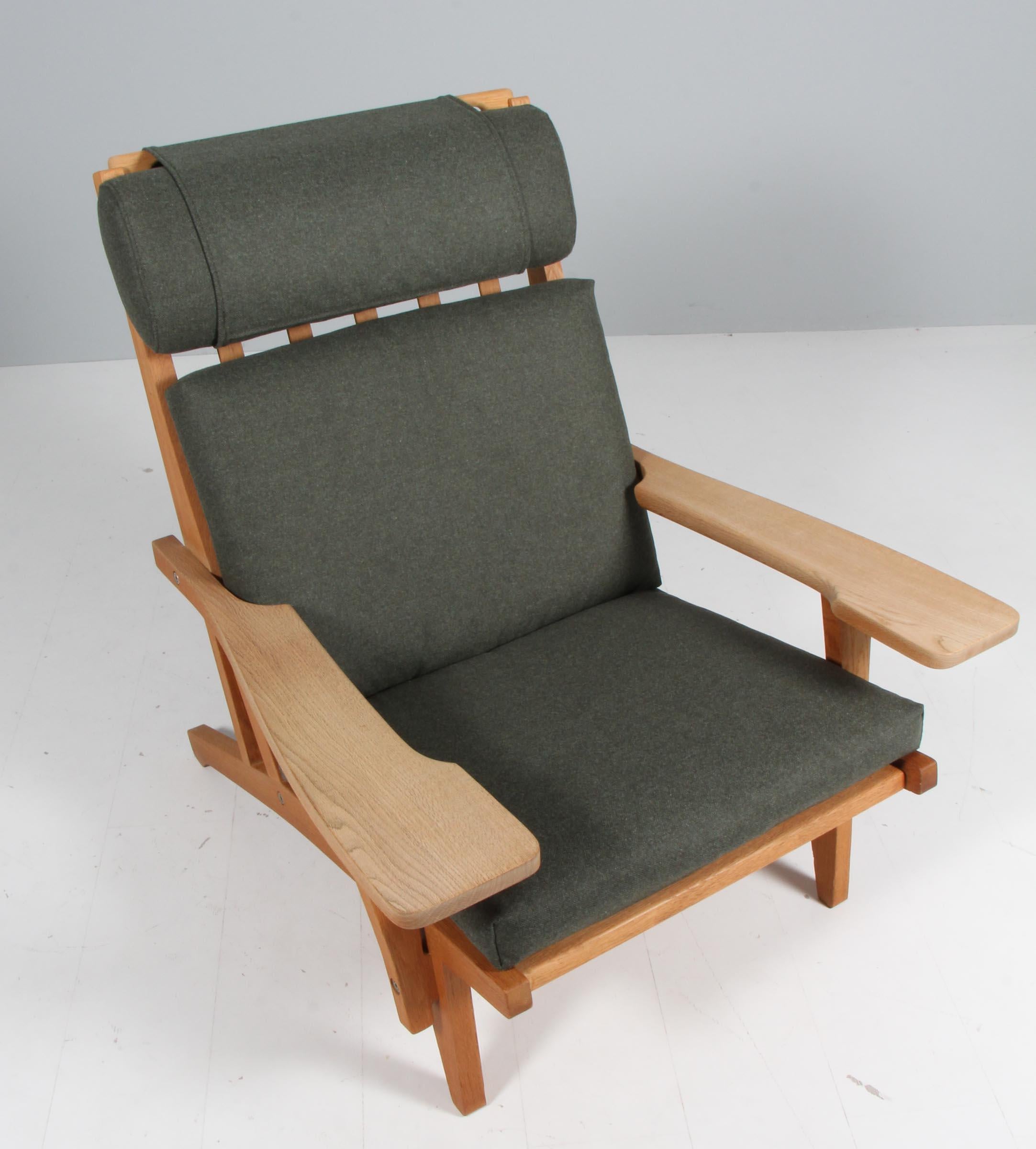 Chaise longue Hans J. Wegner avec coussins détachés, nouvellement recouverte d'un tissu en laine vert Magrethe de Nevotex.

Cadre en chêne. Avec accoudoirs.

Modèle GE-375, fabriqué par GETAMA.
