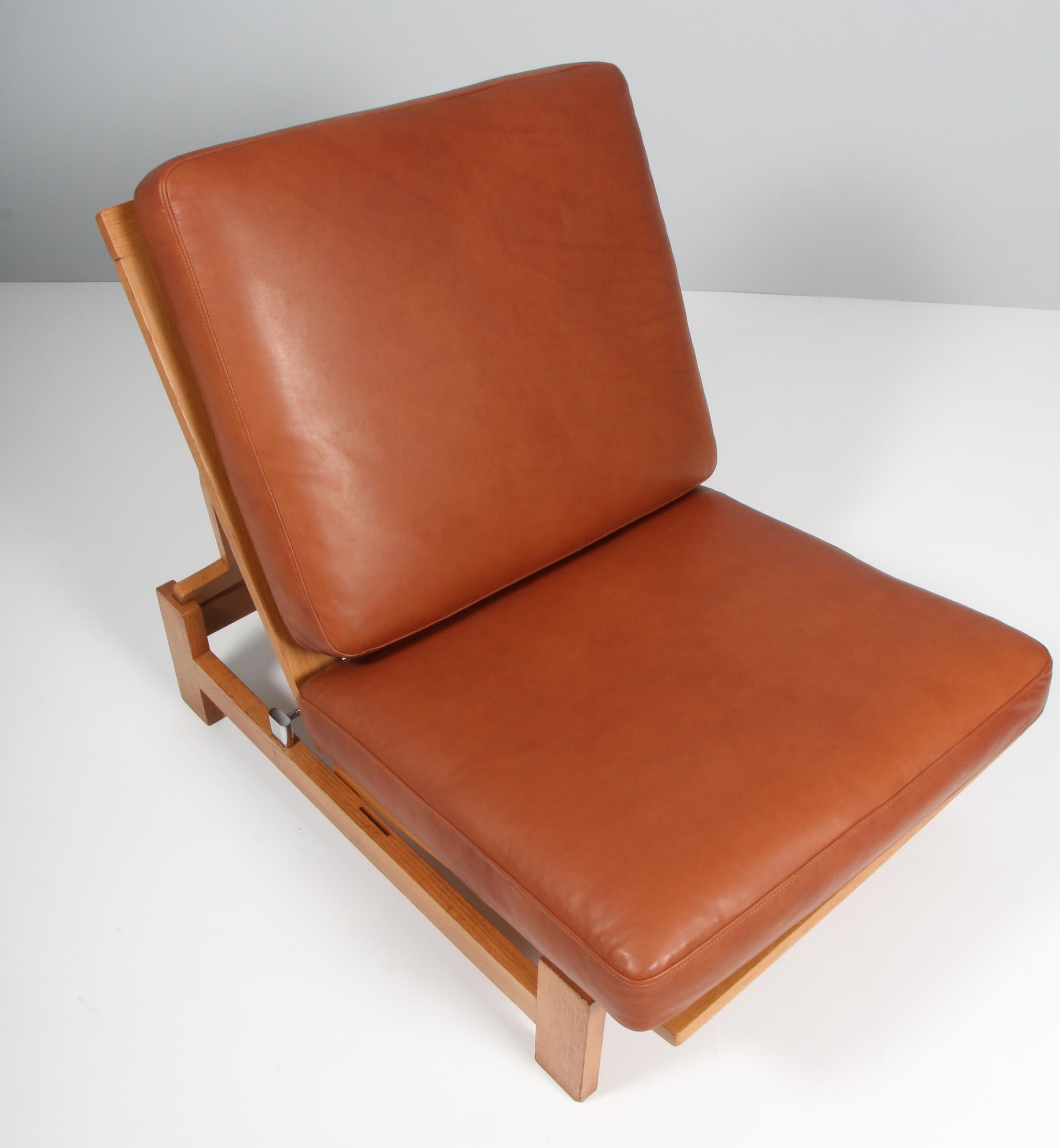 Hans J. Wegner lounge chair and ottoman made of oiled oak

New upholstered with tan aniline leather.

Can lay flat to form a daybed

Model 420, made by GETAMA.

