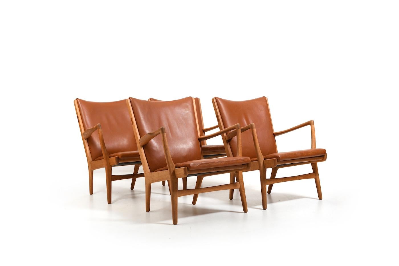 Ensemble de quatre fauteuils, modèle AP-16 par Hans J. Wegner pour AP Stolen Danemark 1951. Fabriqué en chêne et en cuir cognac. Détail teck. Coussins originaux. Produit dans les années 1950. Provinance : Privat collector, Copenhague, Danemark. Tous