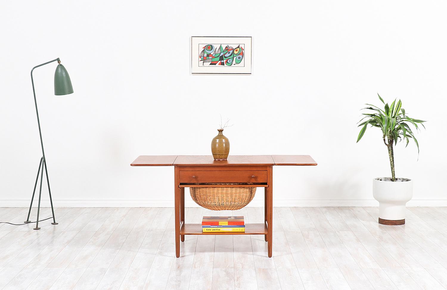 Danish modern sewing table designed by fame architect, Hans J. Wegner. This example was designed in collaboration with the Danish company Andreas Tuck who made most of the tables he designed in Denmark during the 1950s. Like every Wegner design, the