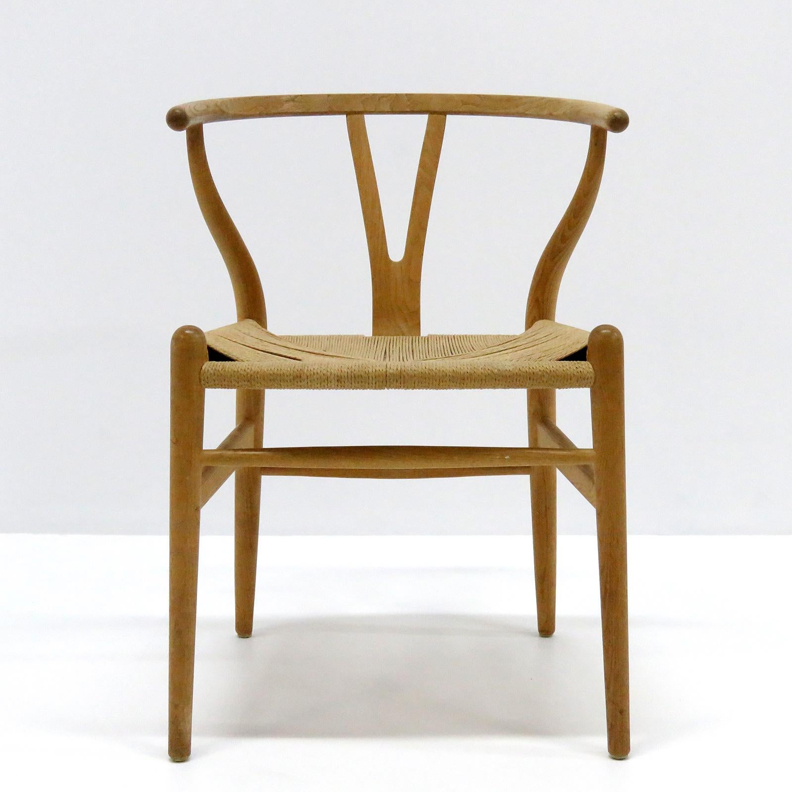 Wonderful model CH-24 dining chairs by Hans Wegner for Carl Hansen & Søn, designed in 1950, in light oak with woven paper cord seat, four seat cushions with significant wear and stains are available on request, marked.