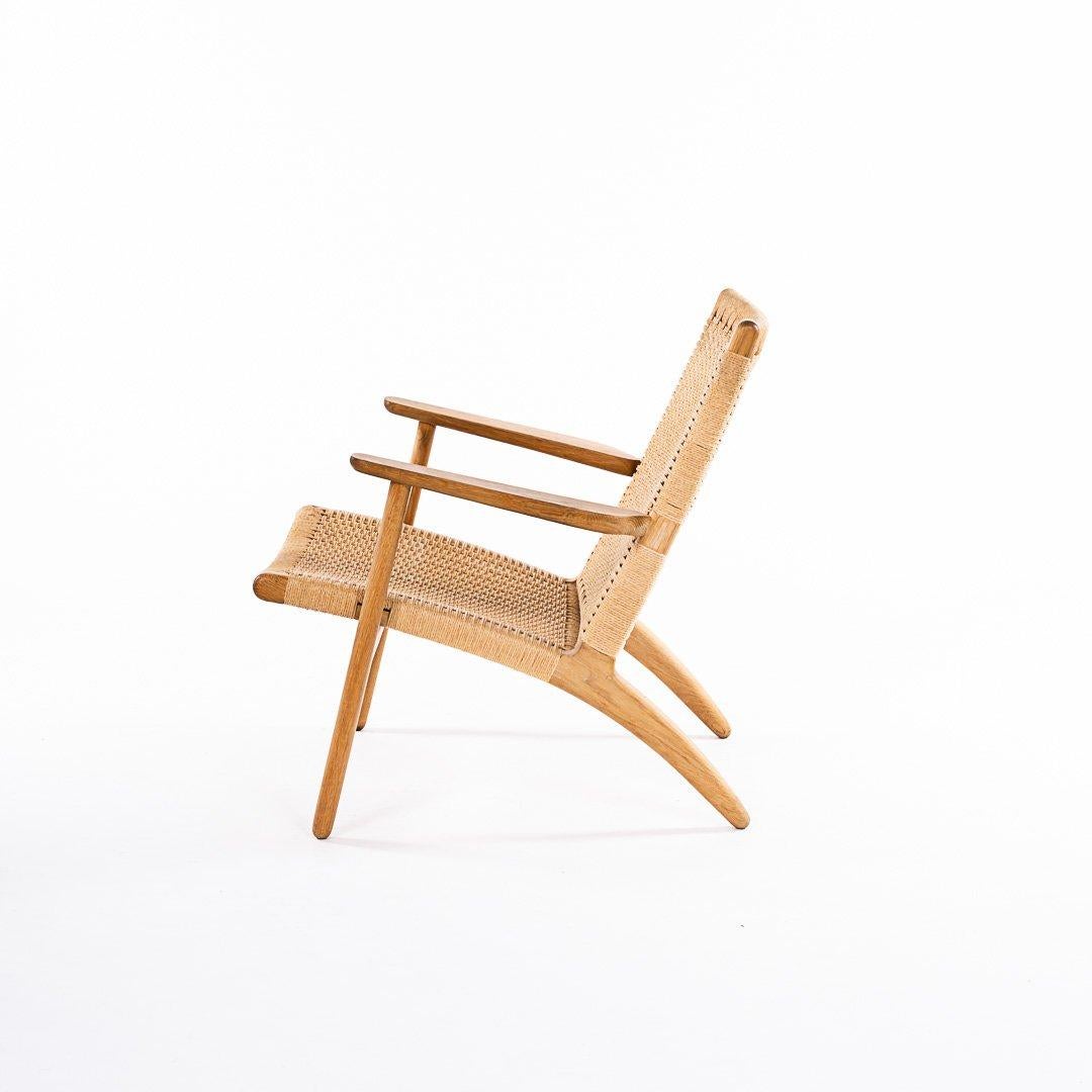 Hans Wegner for Carl Hansen & Son CH 25 lounge chair. Very good condition, marked on underside with Danish maker's label. Frame made in oiled oak. New papercord seat and back restored to exacting standards as the original. This is an original, early