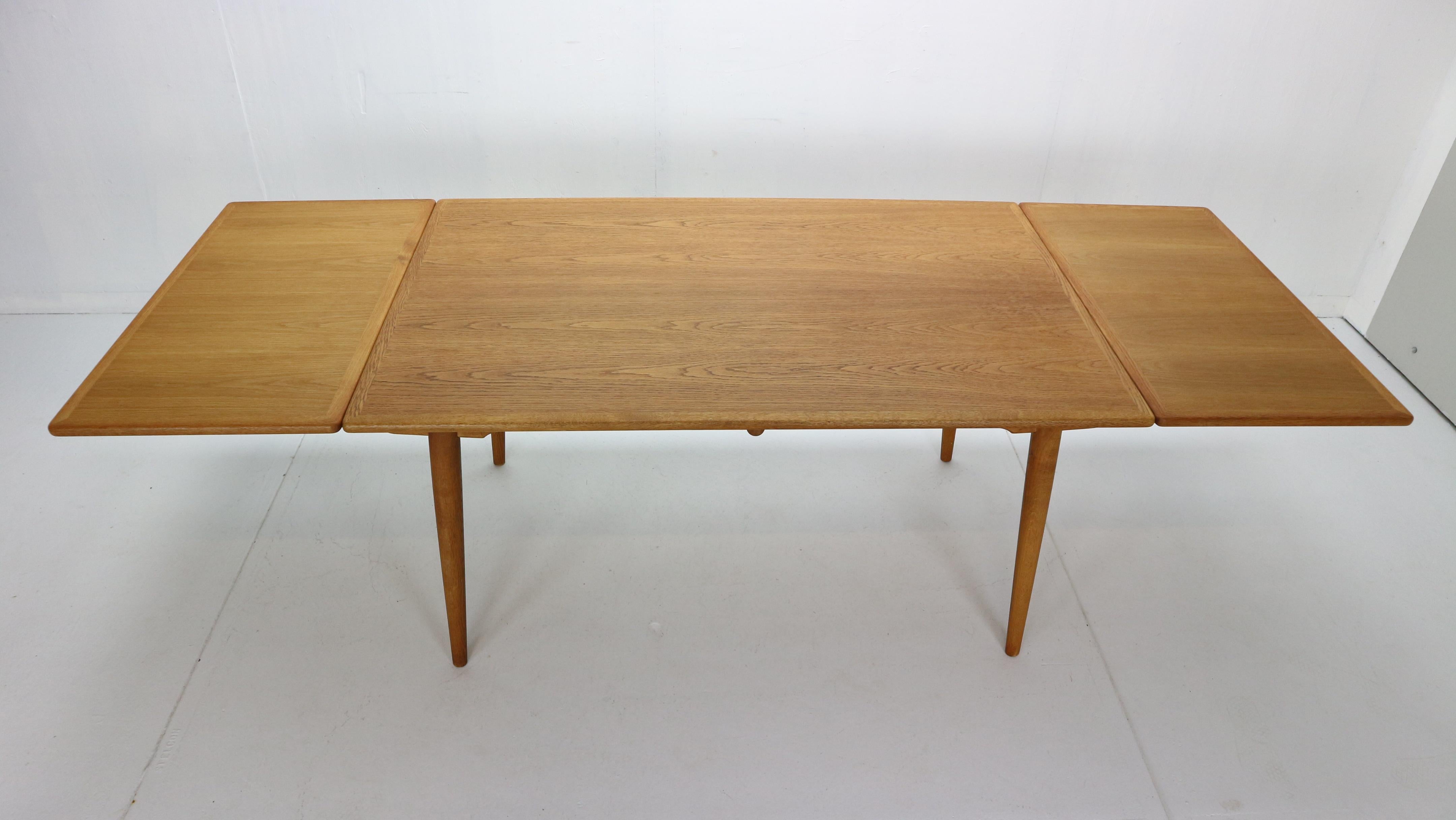 Scandinavian Modern period dining table designed by Hans J. Wegner and manufactured for Andreas Tuck in 1950s period, Denmark.
Extendable dining room table model no. AT-312.
Made entirely of oak wood, with beautiful patina. Has two extra leaves